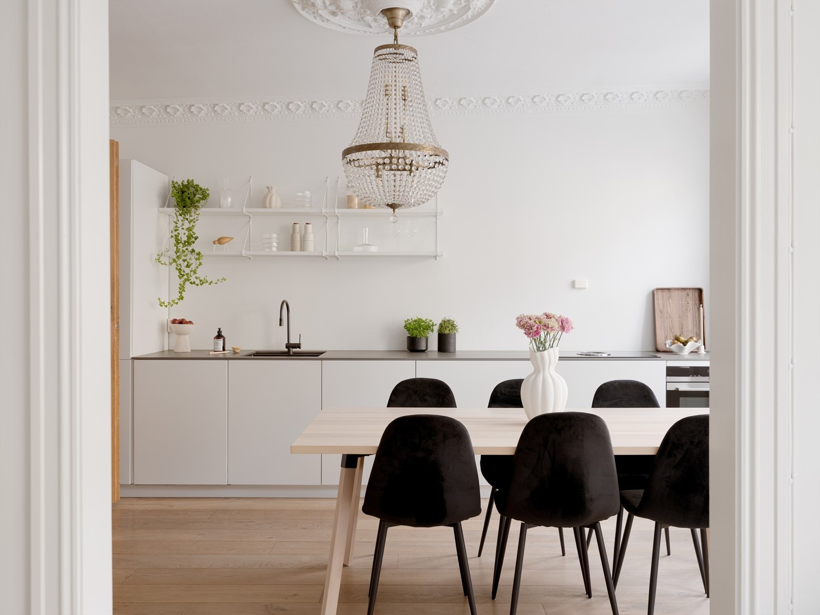 Det stilrene KVIK-kjøkkenet fra 2017 harmonerer elegant med leilighetens klassiske detaljer og har integrerte hvitevarer og kvalitetsmaterialer. Galleribilde