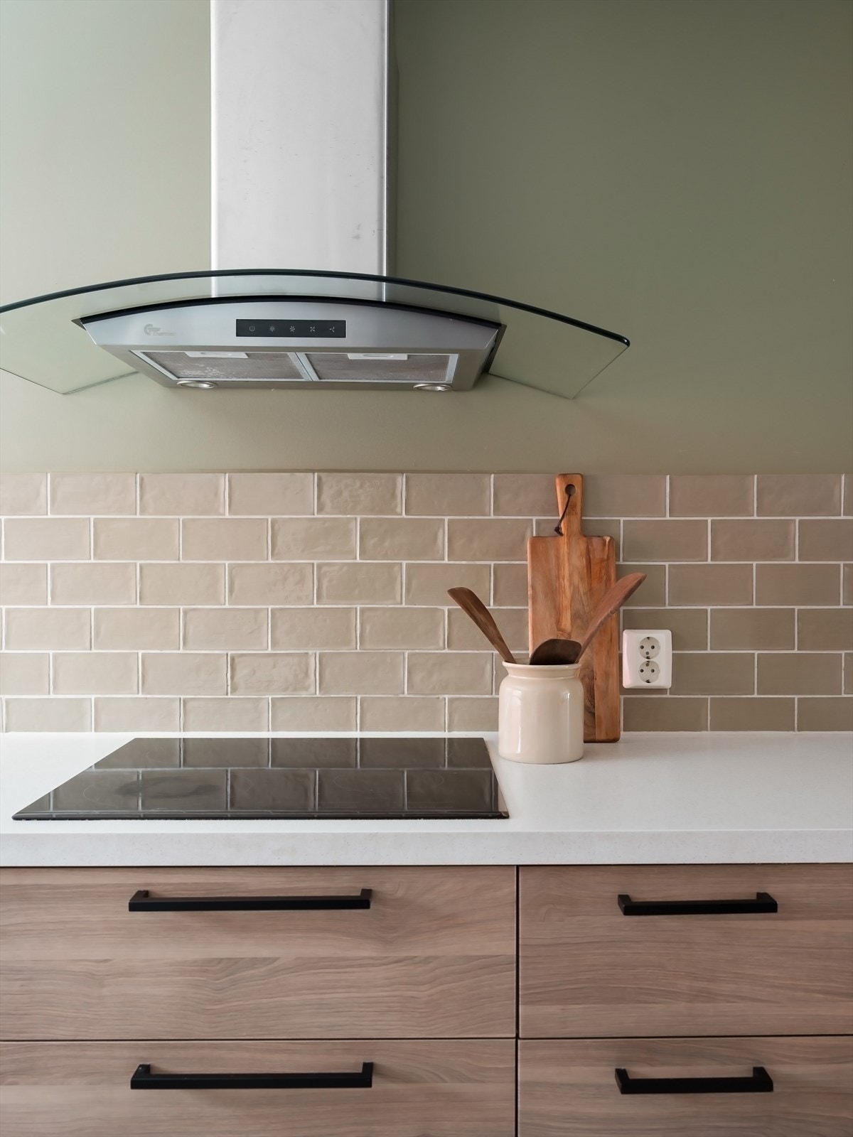 Kjøkkenet har integrerte hvitevarer som induksjonsplatetopp, stekeovn, oppvaskmaskin, kjøleskap og fryser Galleribilde