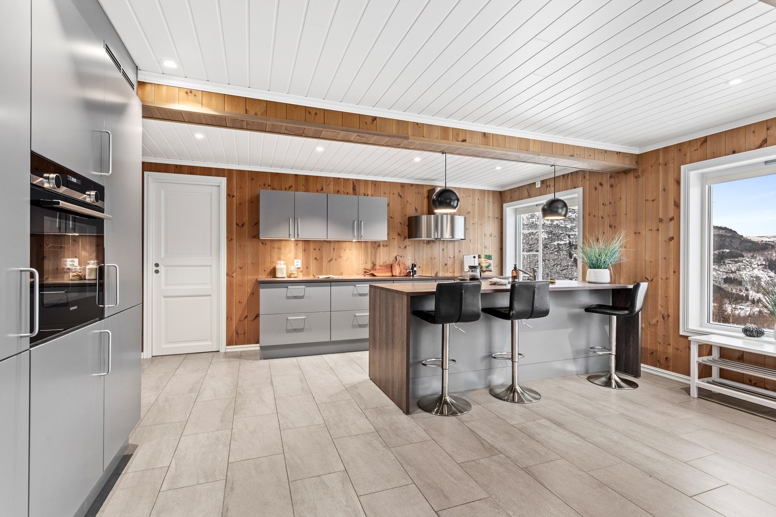 Kjøkkenet har innredning av skåpseksjonar med glatte måla frontar, og enkelte finerte dekksider. Galleribilde