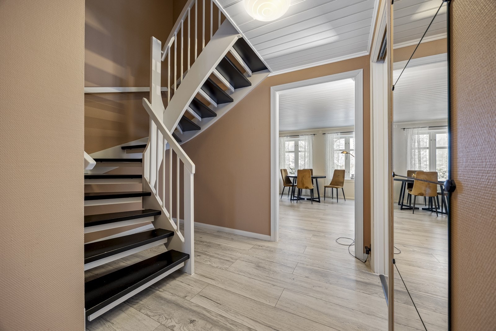 Malt tretrapp med sving gir tilgang til andre etasje fra entréen. Galleribilde