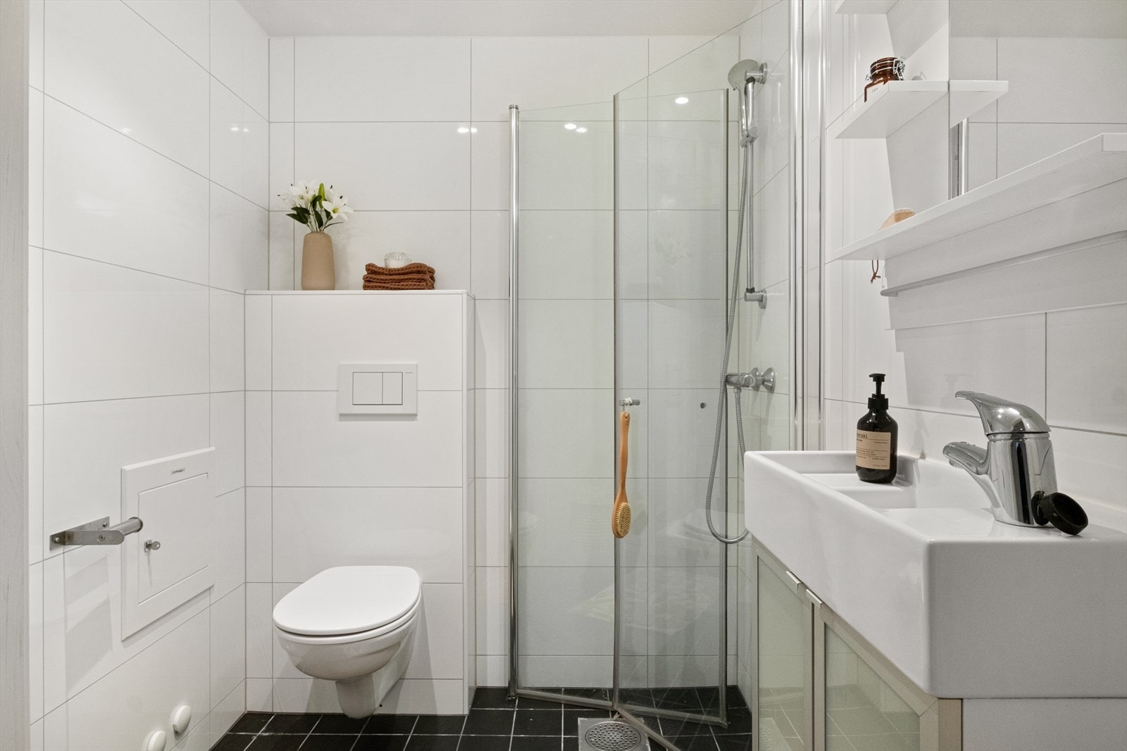 Flislagt baderom med varmekabler, avtrekk, speil, armatur, downlights, opplegg for vaskemaskin, servant med innredning, dusj hjørne med innfellbare glassdører, vegghengt toalett. Galleribilde