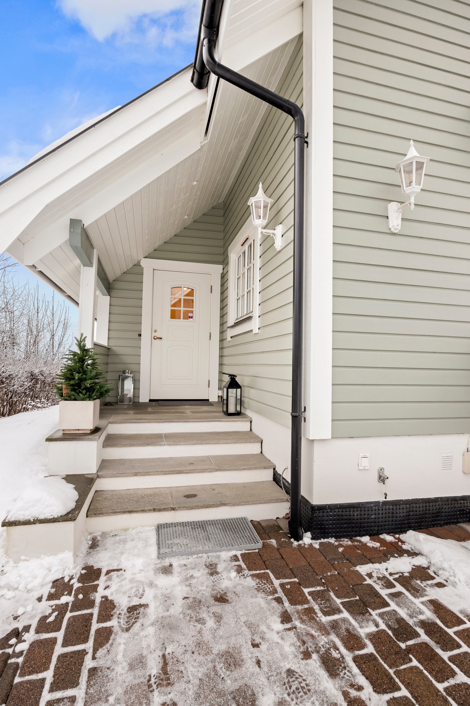 Boligen har hyggelig overbygd inngangsparti med støpt trapp med skifer i trinn og på repos. Galleribilde