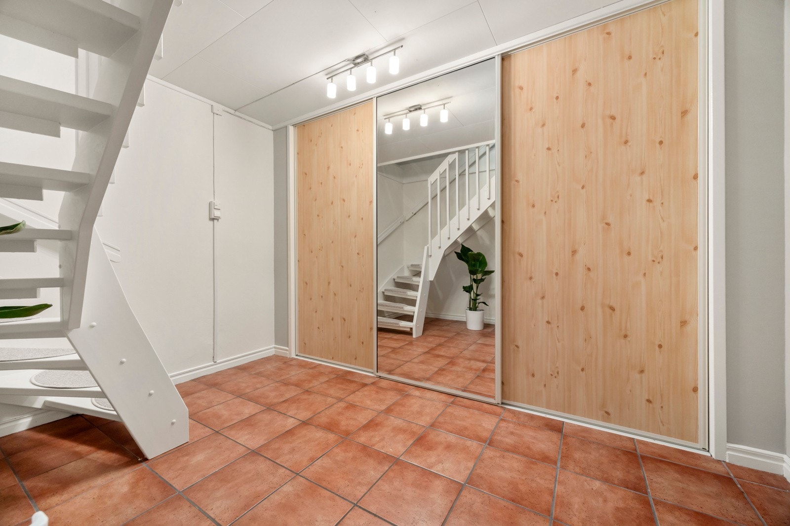 Underetasjen har gang med flislagt gulv med varmekabler og skyvedørsgarderobe. Galleribilde