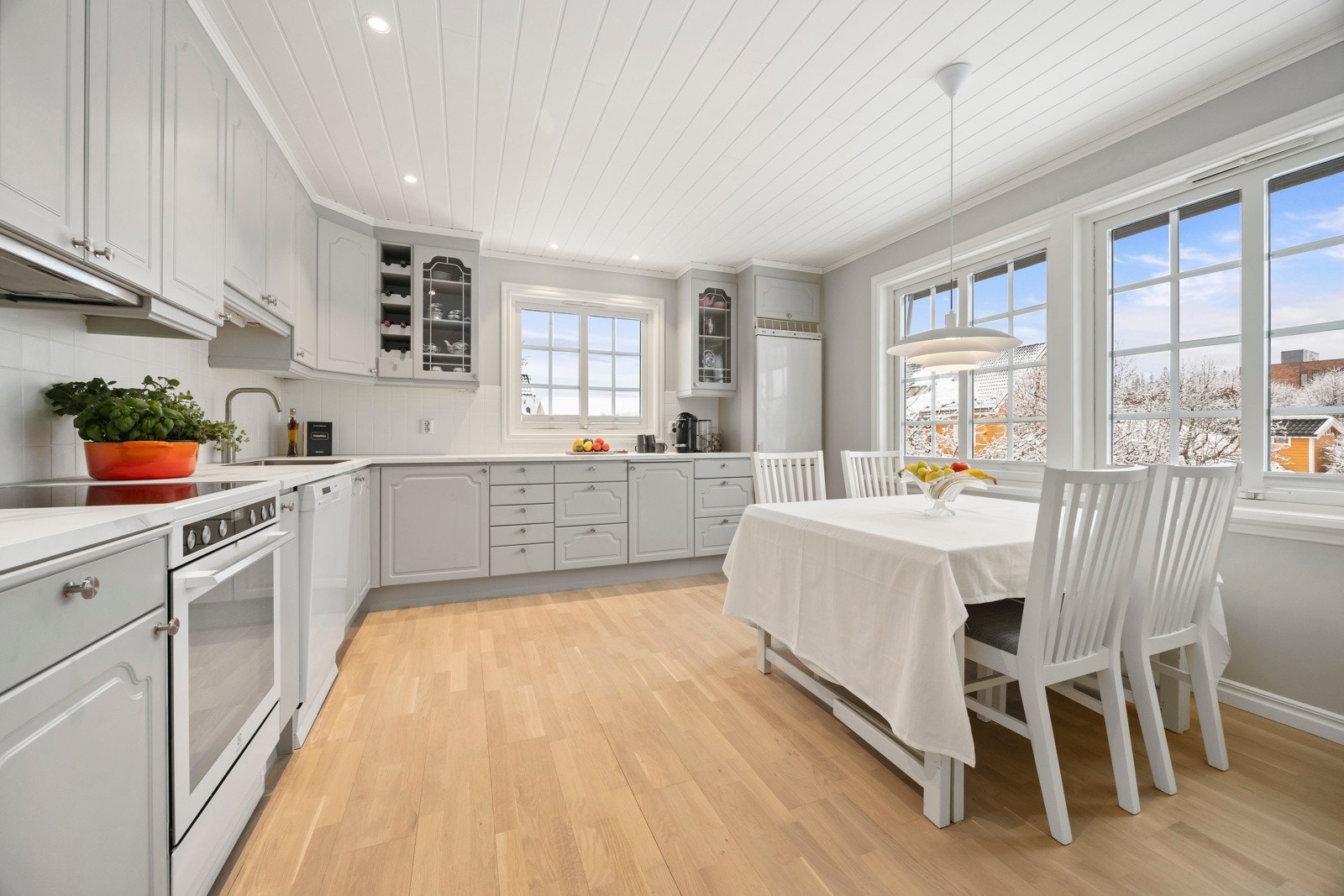 Stort og innholdsrikt kjøkken hvor familien kan samles. Innredningen har profilerte fronter som ble malt og fikk nye laminat benkeplater i 2025. Galleribilde