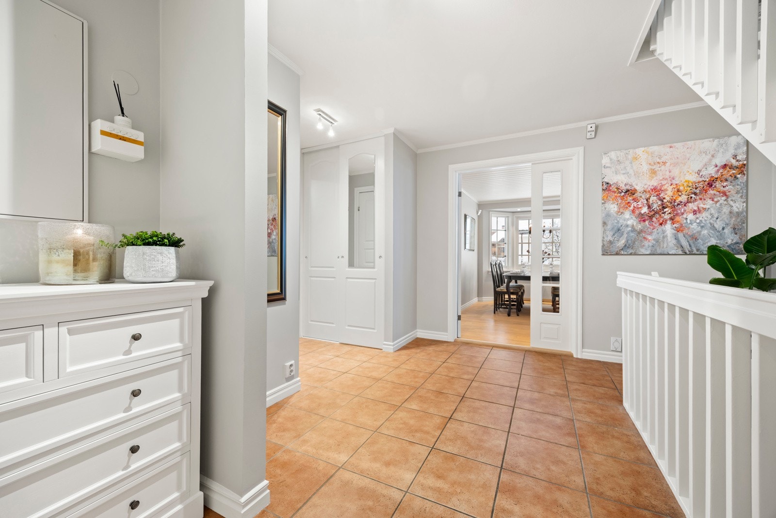 Romslig, flislagt hall med varmekabler og skyvedørsgarderobe. Galleribilde