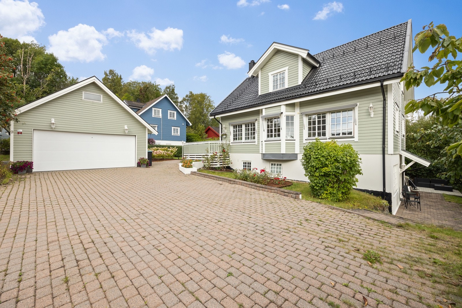 Gårdsplassen er steinbelagt og har romslig oppstillingsplass foran garasjen med plass til 3-4 biler. Galleribilde
