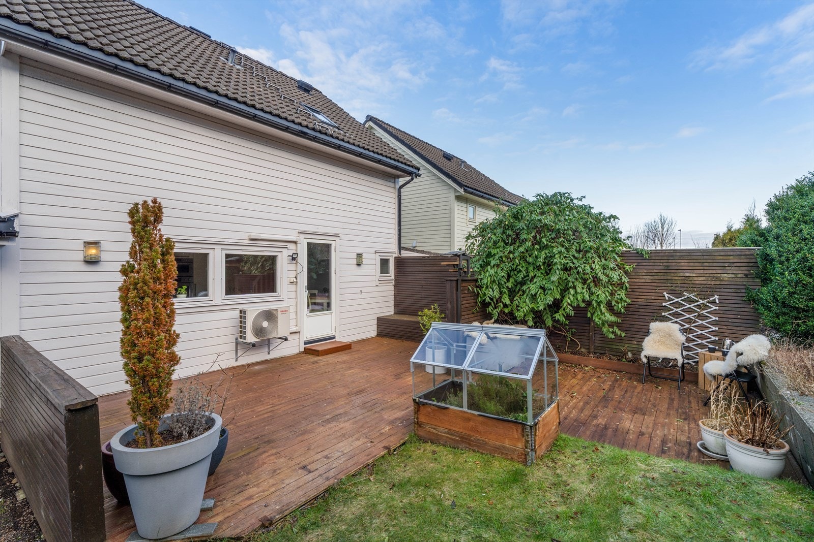 Koselig uteområde med terrasse og plen Galleribilde