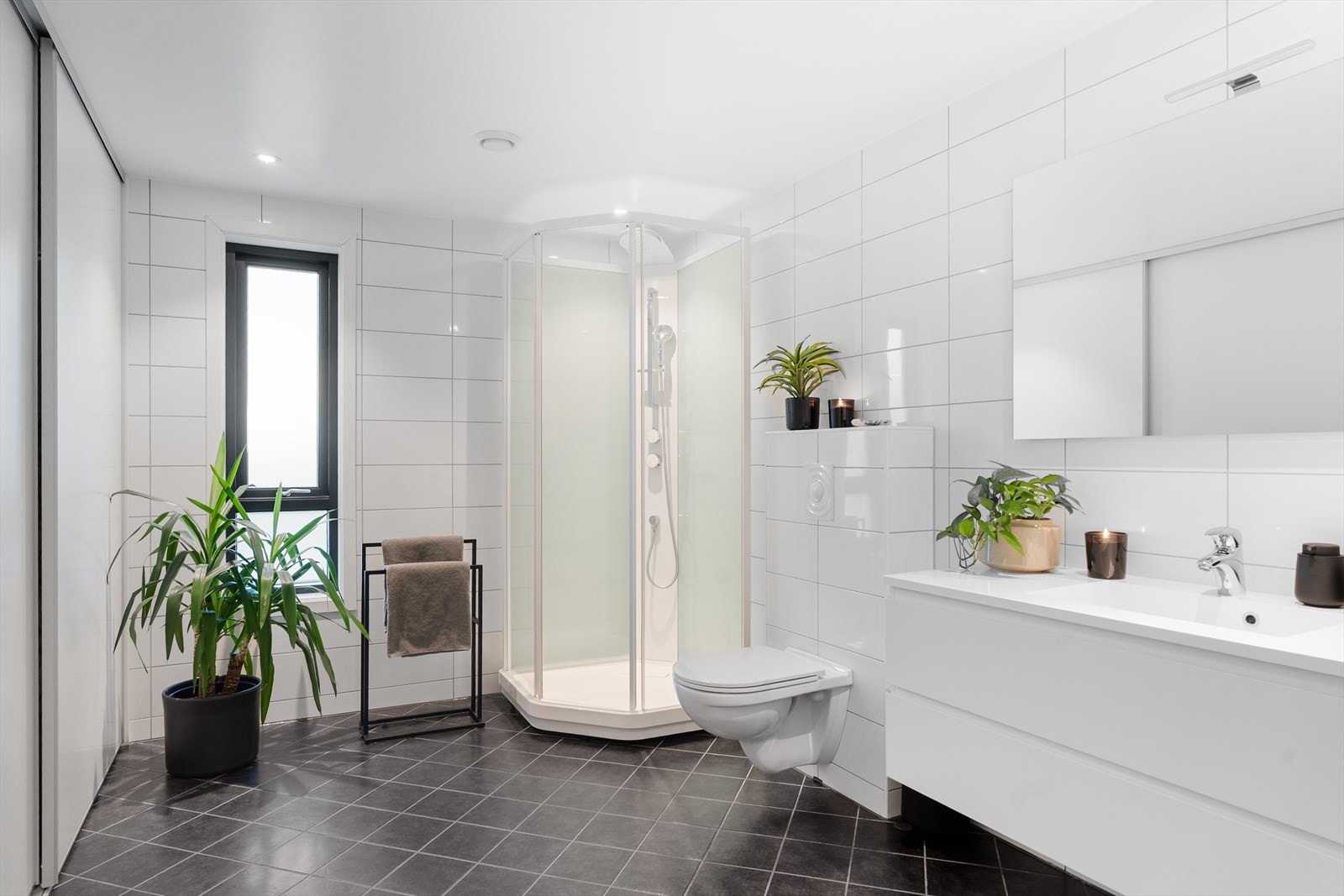 Meget romslig og behagelig bad/vaskerom som inneholder dusjkabinett, seksjon med heldekkende vask, opplegg for
vaskemaskin og veggmontert toalett. Galleribilde