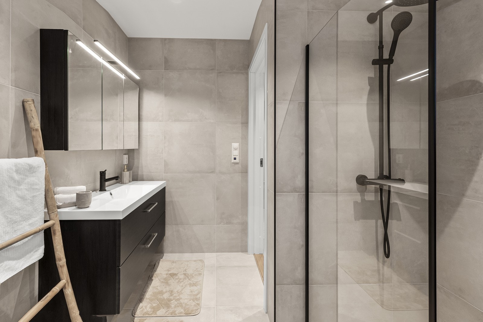 Badet i andre etasje er delikat innredet med store, lyse fliser. (Bilde fra speilvendt bolig). Galleribilde