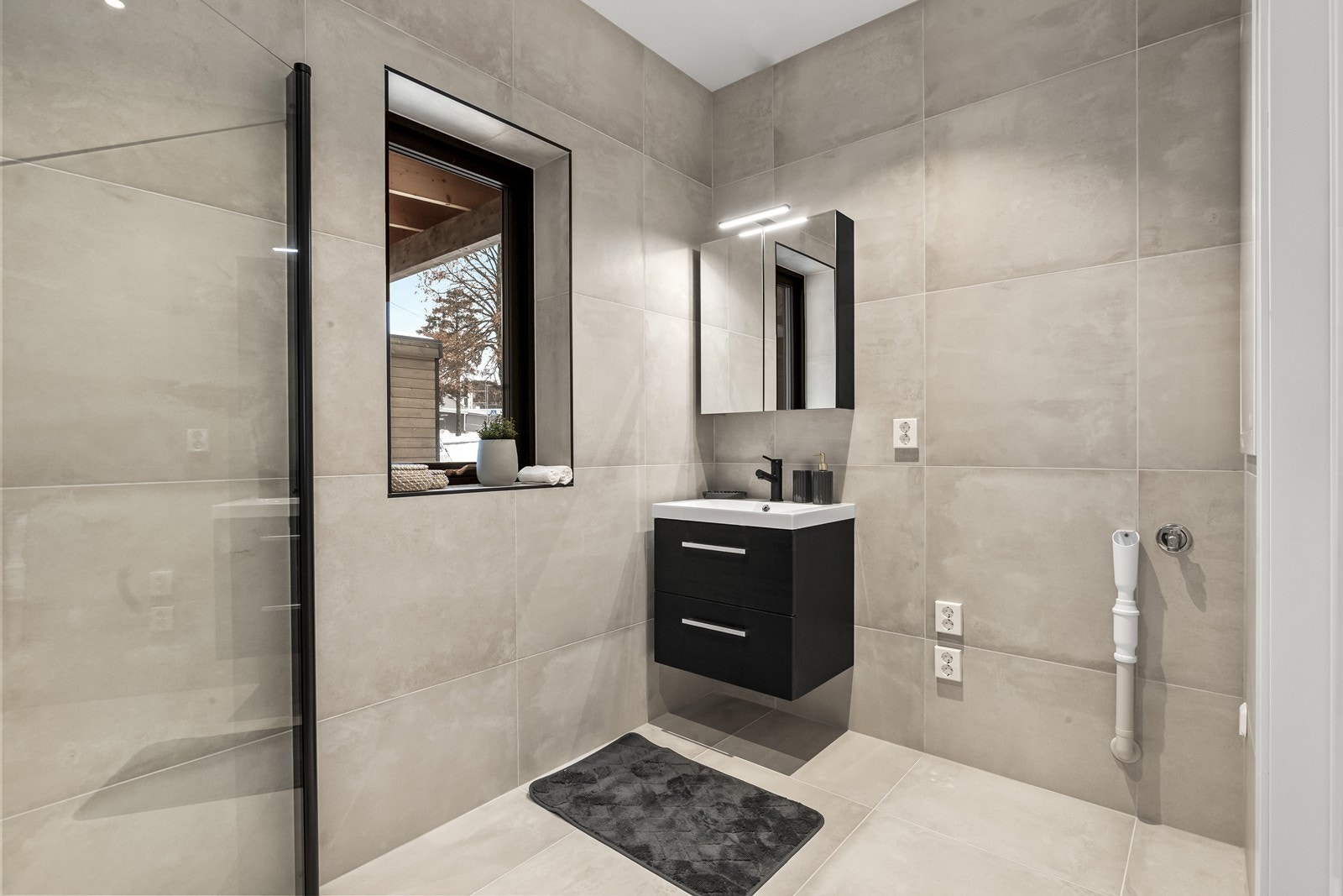 Moderne baderomsinnredning med oppbevaringsplass i skuffer og speilskap. (Bilde fra speilvendt bolig). Galleribilde