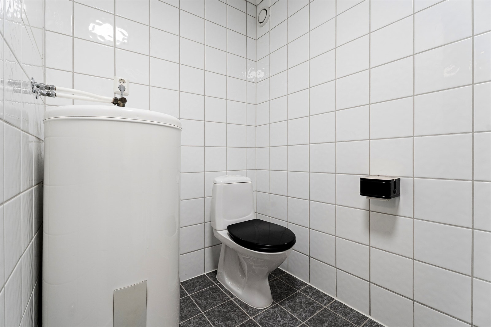 Flislagt bad med funksjonell planløsning og nøytrale overflater. Galleribilde