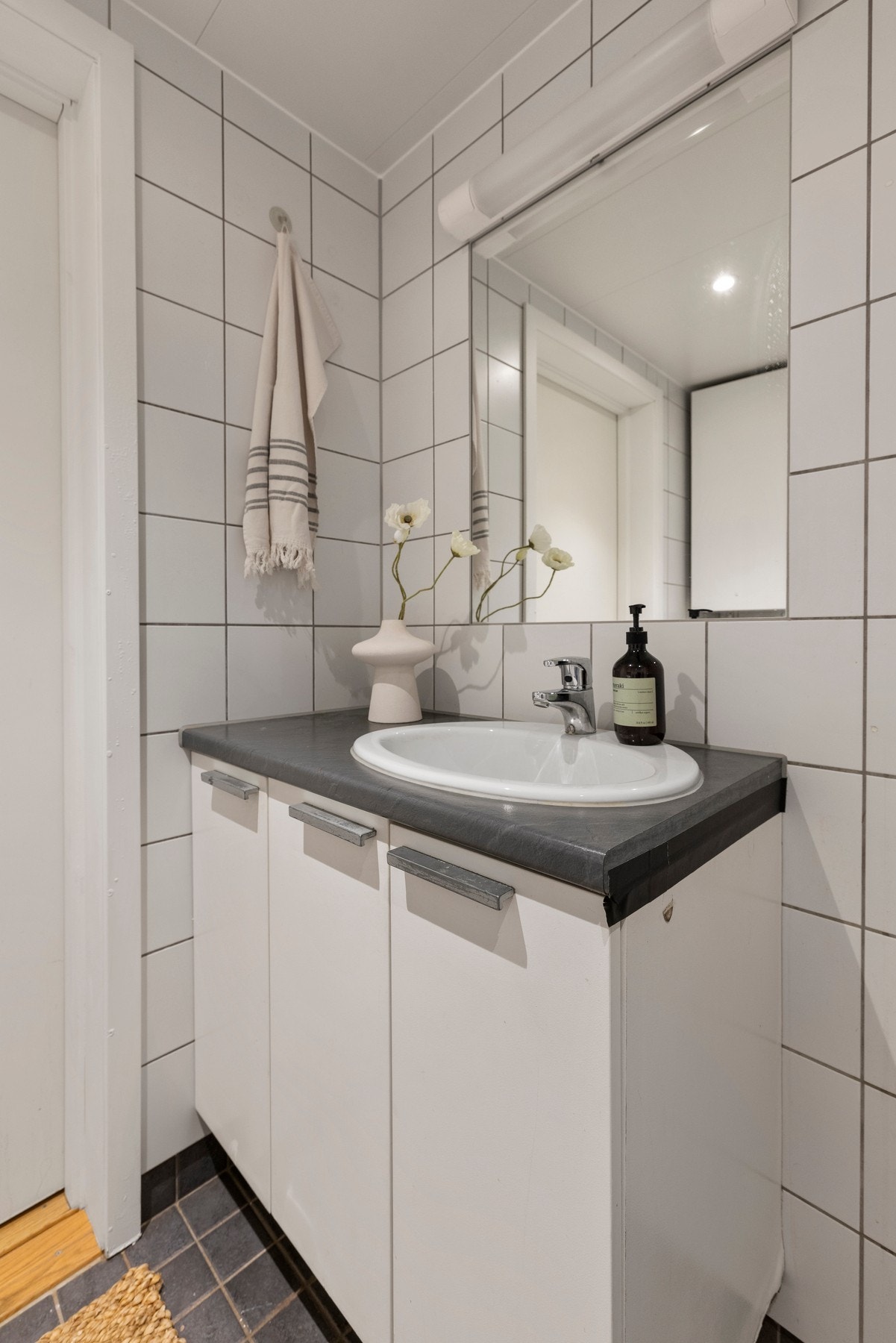 Badet er innredet med åpen dusjløsning, vegghengt toalett, baderomsinnredning med nedsunket servant, stort veggspeil Galleribilde