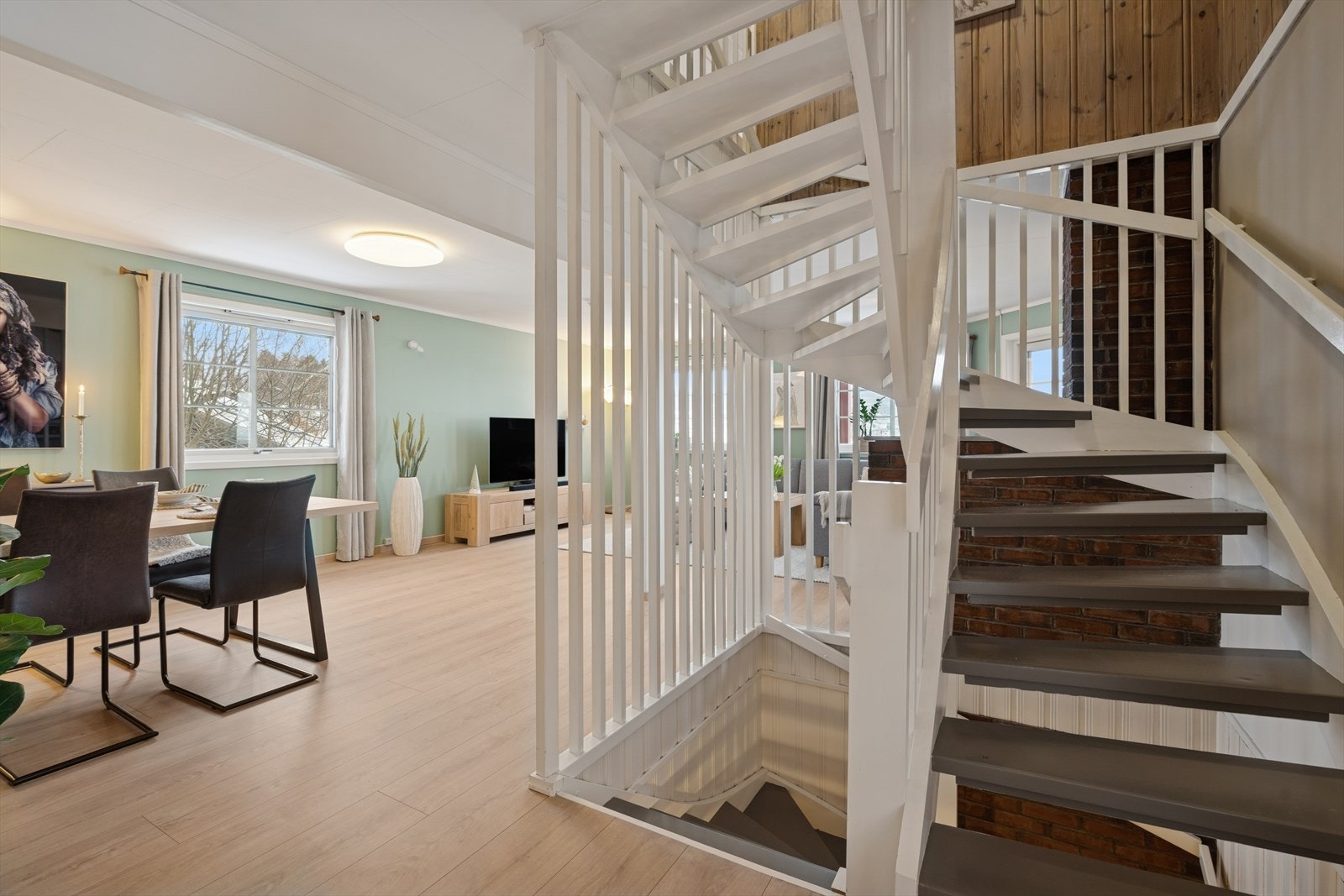Fra stuen leder en trapp deg både ned til underetasjen og opp til loftsetasjen, noe som gir en praktisk og naturlig flyt mellom boligens etasjer. Galleribilde