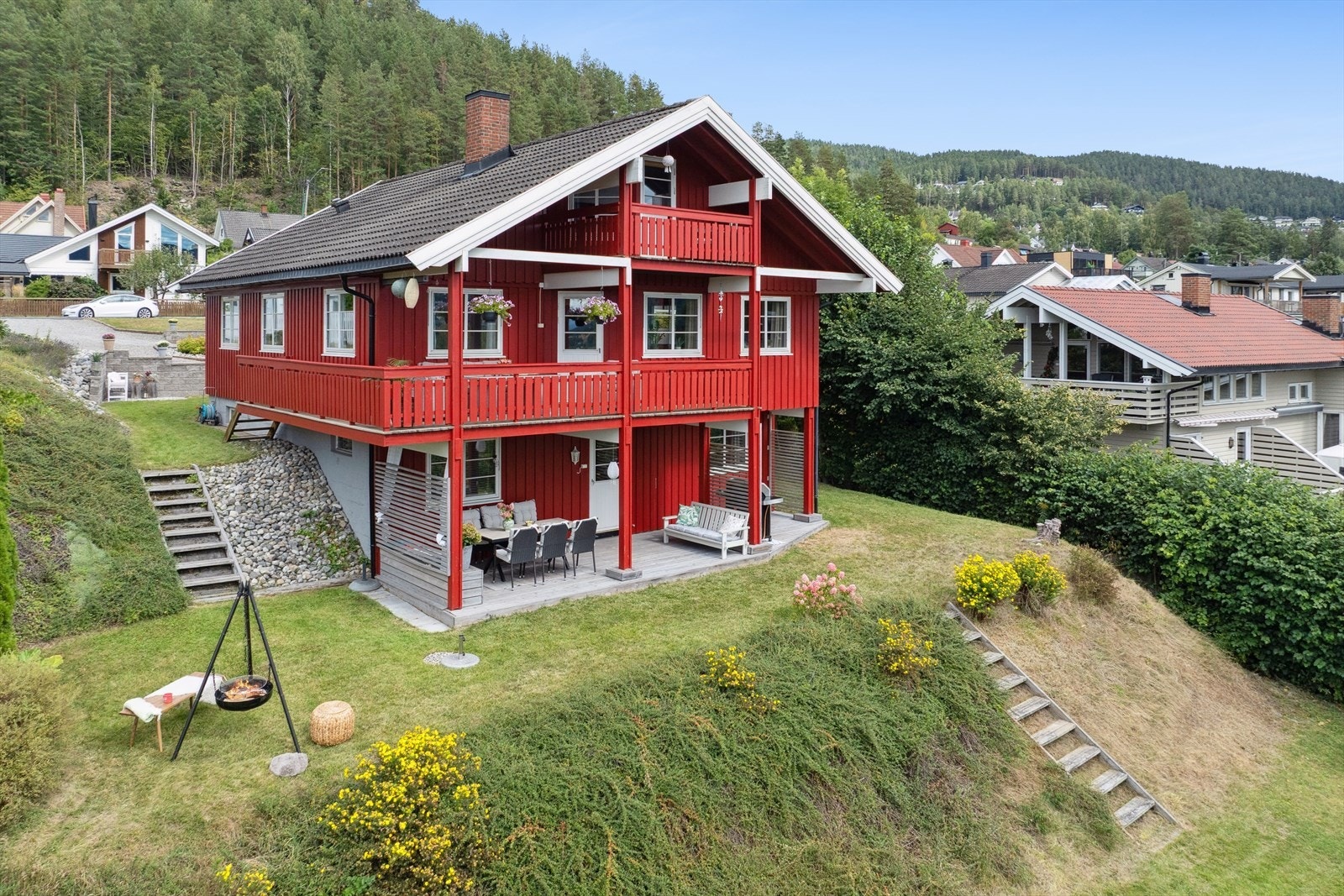 Tomten ligger i skrånende terreng, og er pent opparbeidet med trapper, plen, trær og annen beplantning. Galleribilde