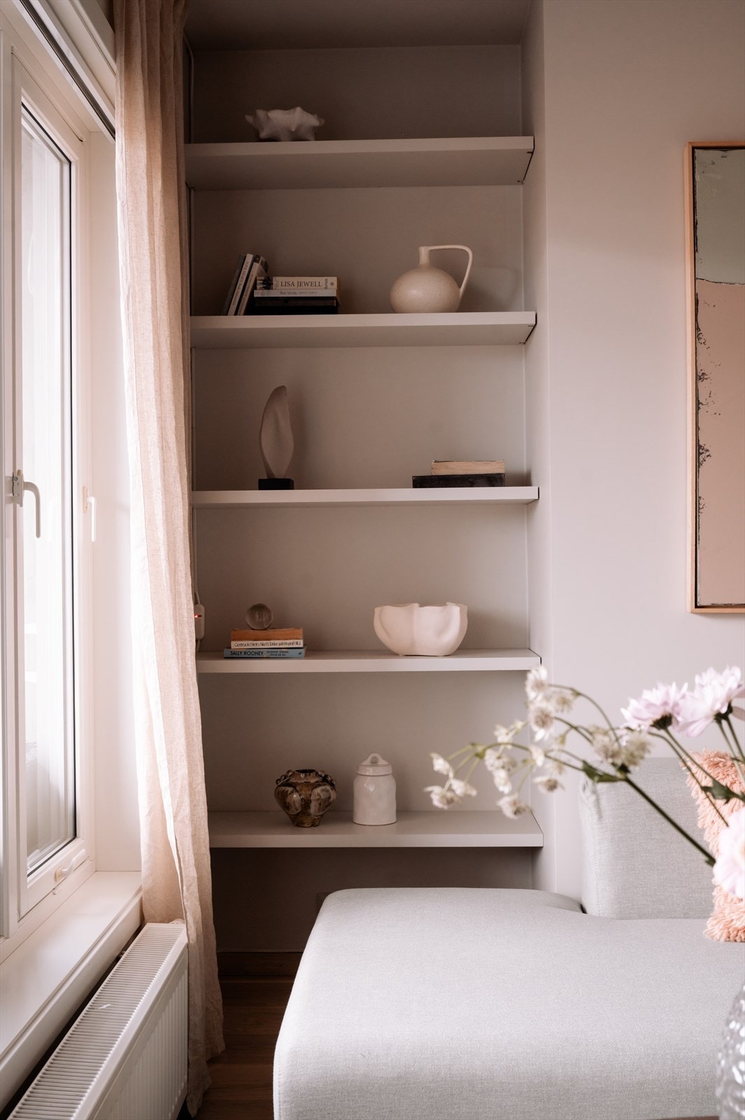 Små detaljer, som en praktisk hylleløsning bak sofaen, gir stuen et gjennomført og helhetlig preg Galleribilde