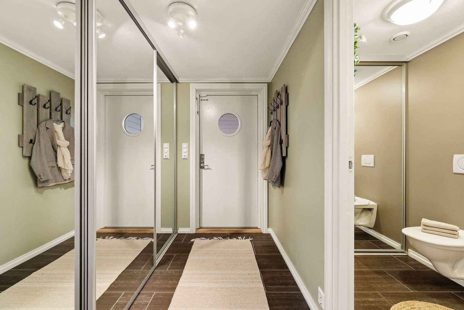 Lys og trivelig gang med tiltalende fliser på gulvet (varmekabler) og skyvedørsgarderobe med speilglass. Galleribilde