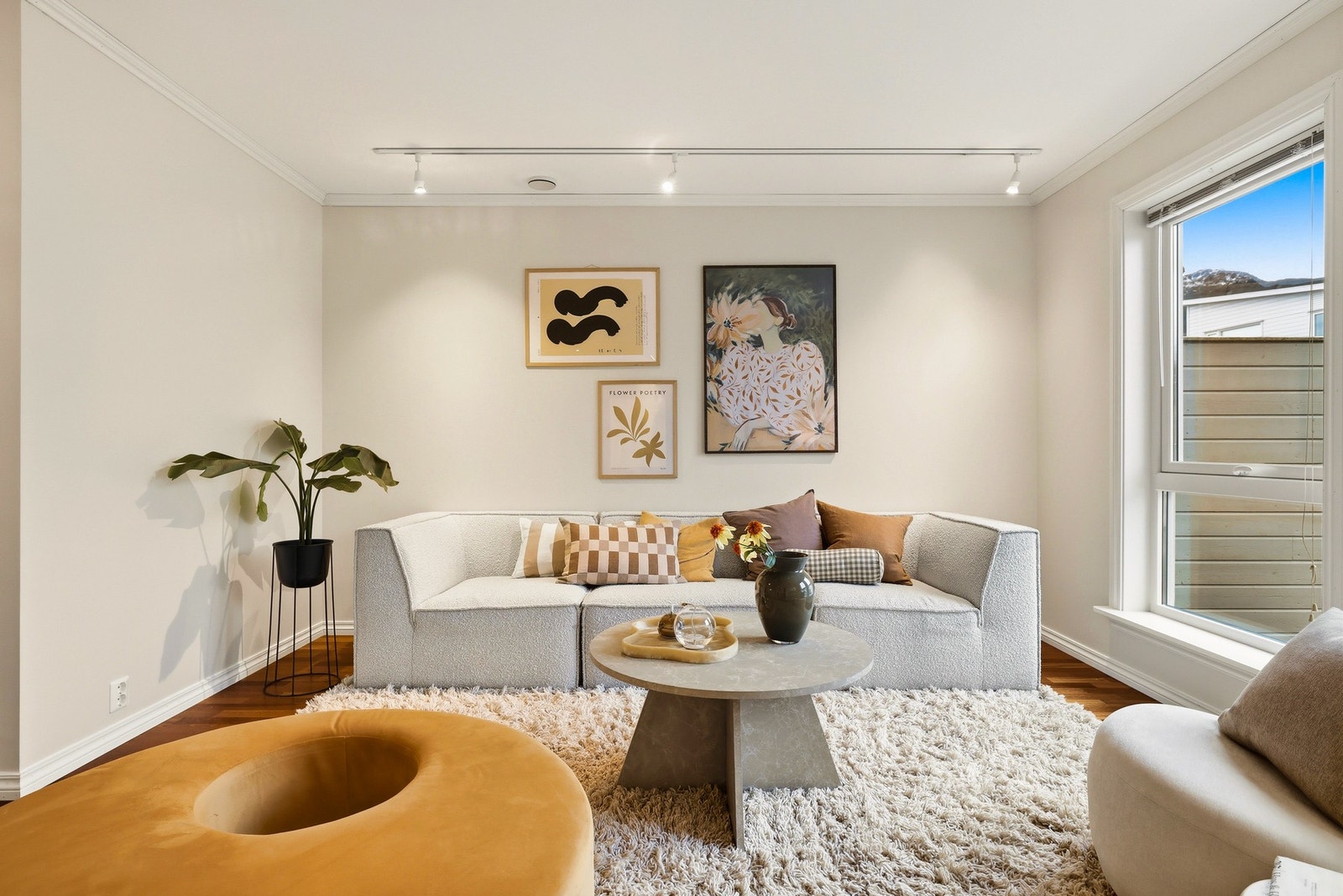 Koselig dagligstue med takbelysning og stort vindu, som gir gode lysforhold. Galleribilde