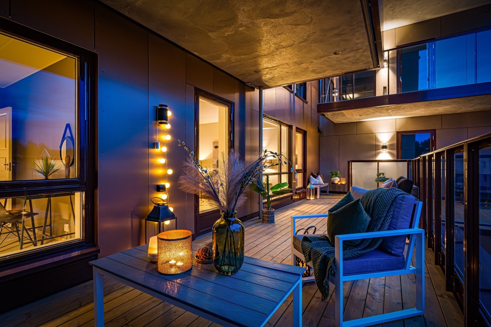 Balkongen er delvis overbygget med terassegulv og impegrenert treverk Galleribilde