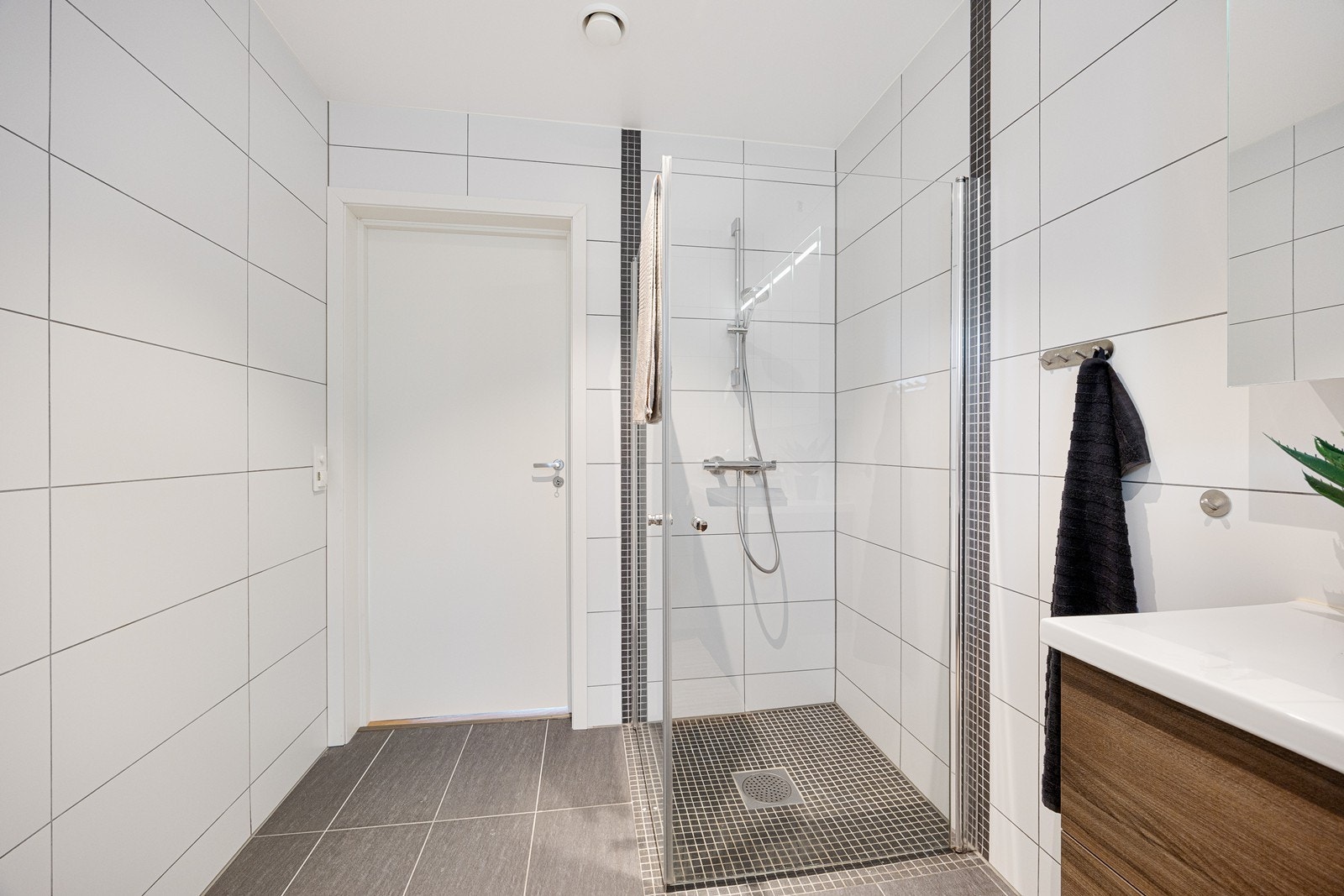 Dusjen har innfellbare dusjdører i herdet glass. Galleribilde