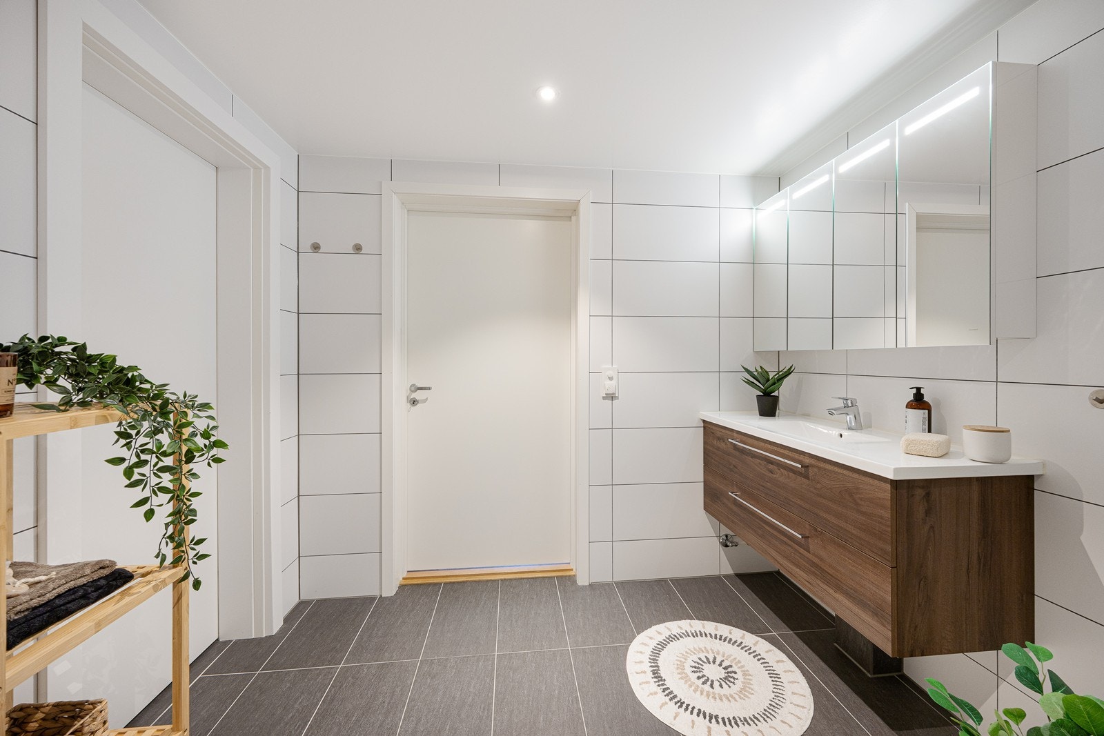 Begge bad har behagelig gulvvarme, pene fliser, dusj med innfellbare dusjdører, vegghengt toalett og en lekker servant med speilskap over. Galleribilde