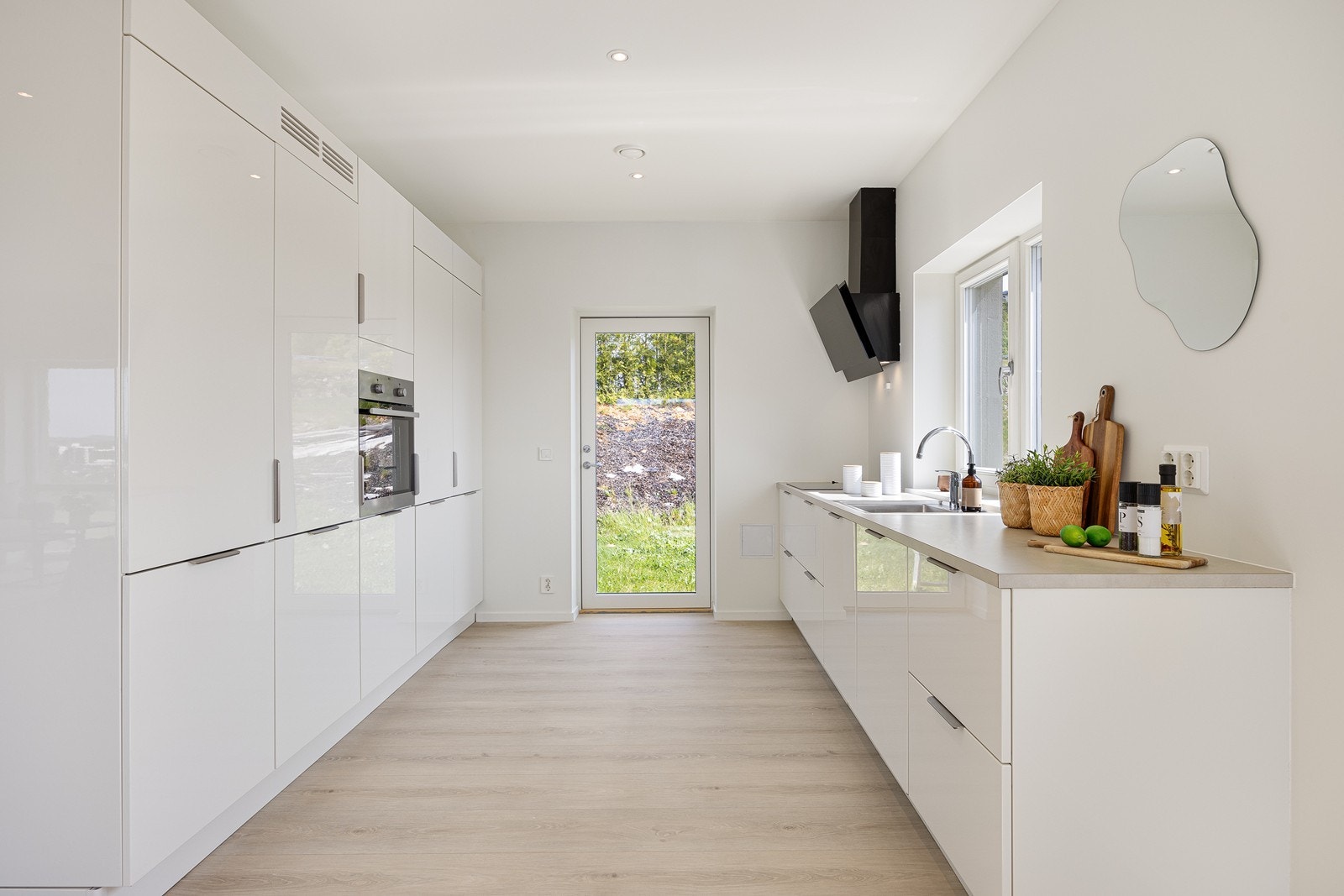 Kjøkkenet er gjennomført i hvit høyglans og har integrerte hvitevarer. Galleribilde