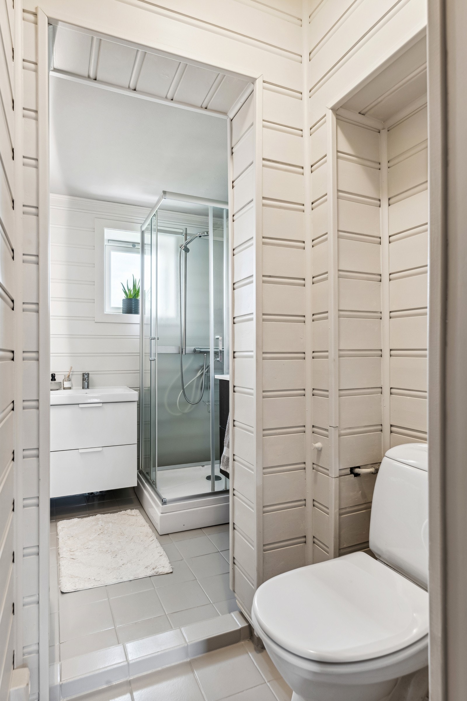 Bad og toalettrom er på 3,5 kvm. Det har fliser på gulv og malt panel på vegger. Galleribilde