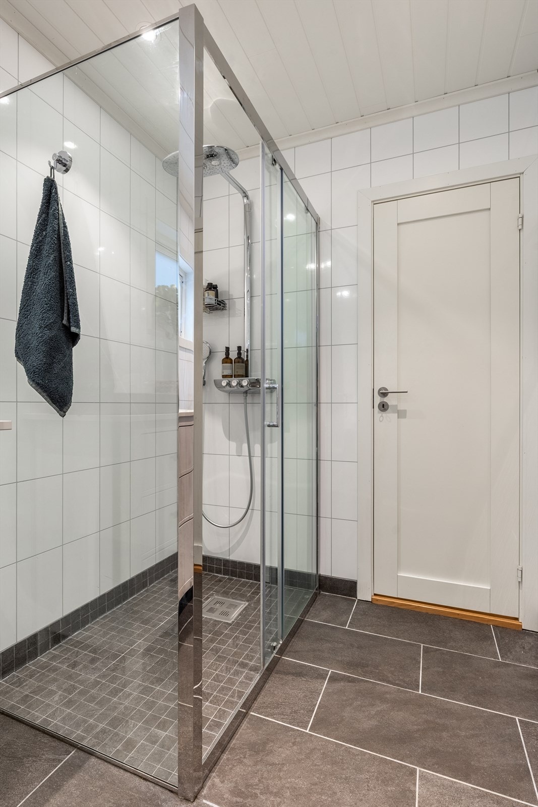 Badet er innredet med dusjhjørne, toalett og vask Galleribilde