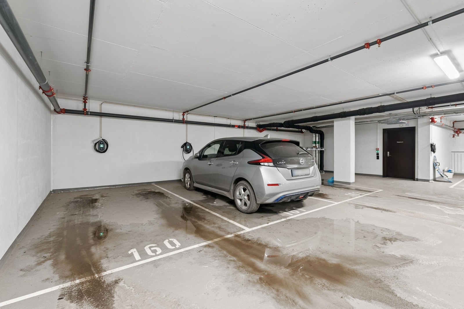 Parkeringsplass i lukket anlegg – fast plass med elbillader i tilknyttet parkeringskjeller. Galleribilde