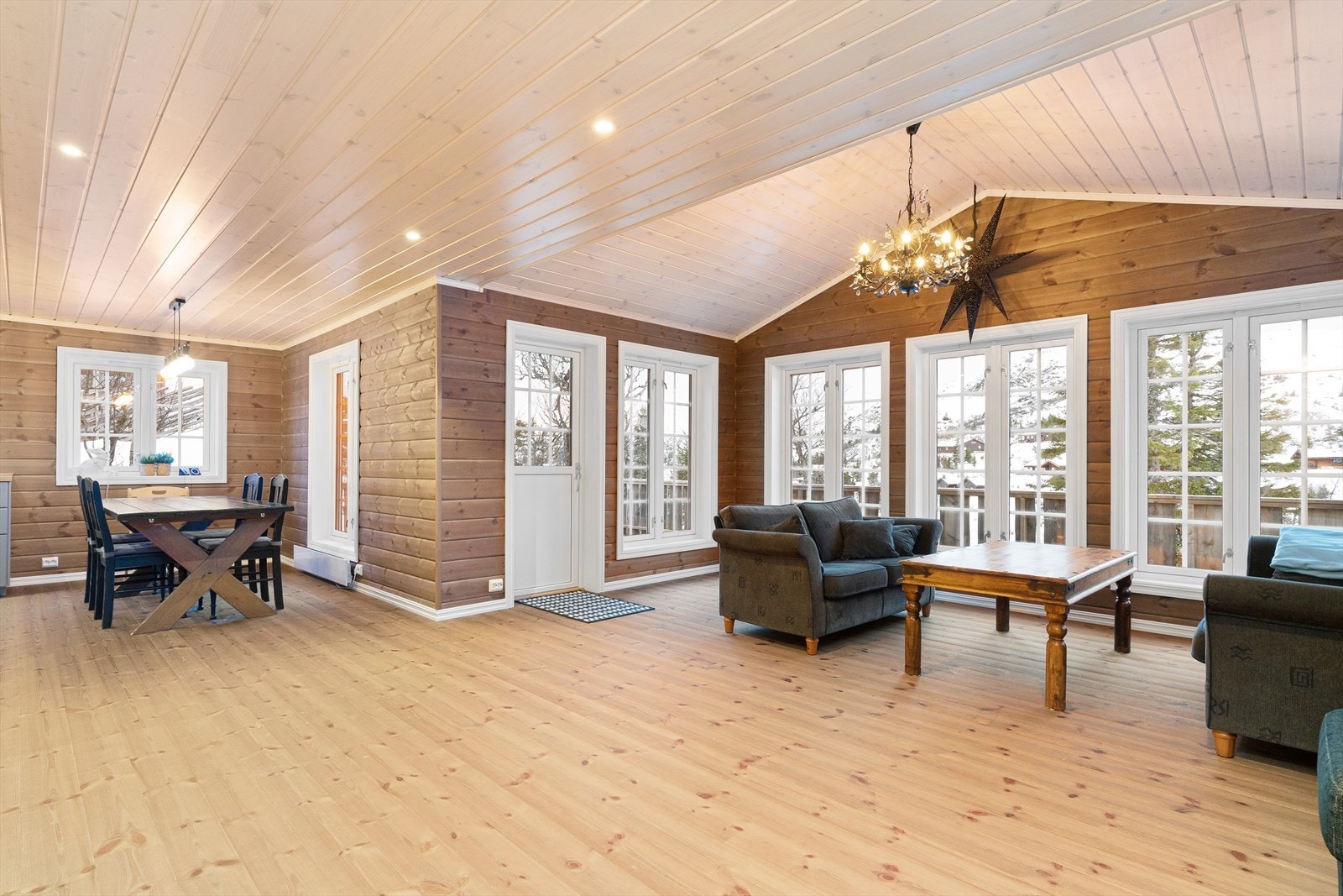 Stor og innbydende stue med en stavs heltre furugulv og trepanel på vegg. Stuen har store vindusflater, som bringer den vakre utsikten inn og gir flott romfølelse med mye naturlig lys. Galleribilde