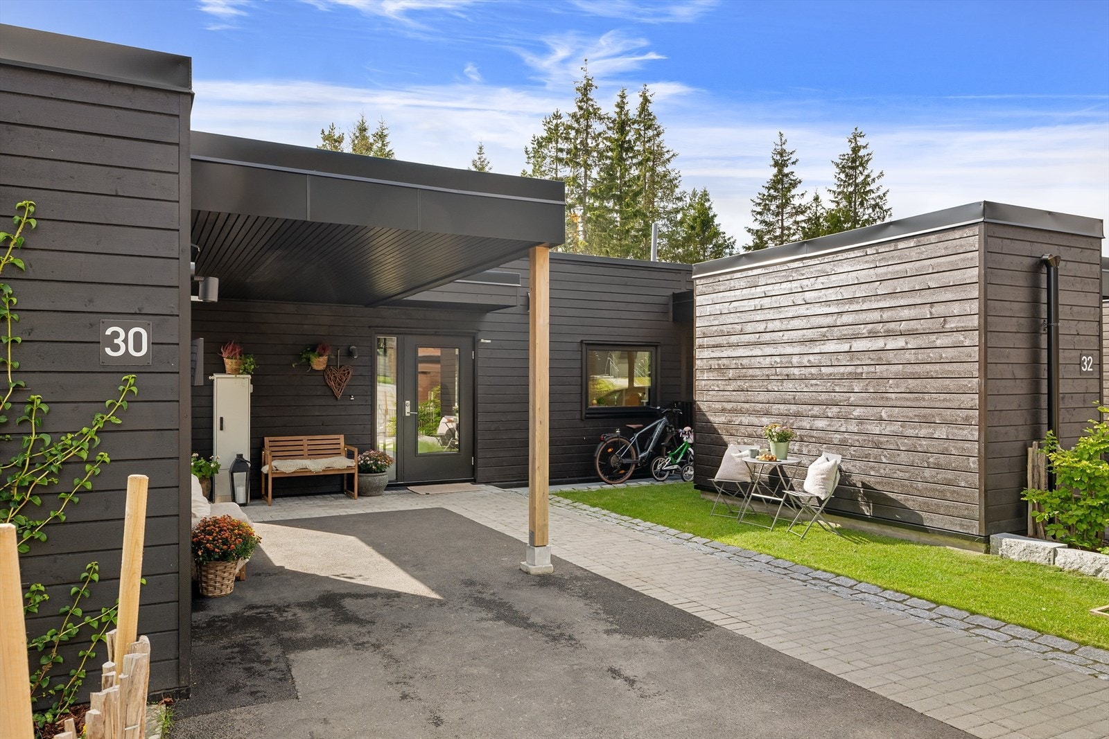 Det er enkelt for hverdagslogistikken å ha egen parkeringsplass med elbil-lader i carport. Utebod på 5m2. Her er det også plass til oppbevaring av sykler og barnevogner. Galleribilde