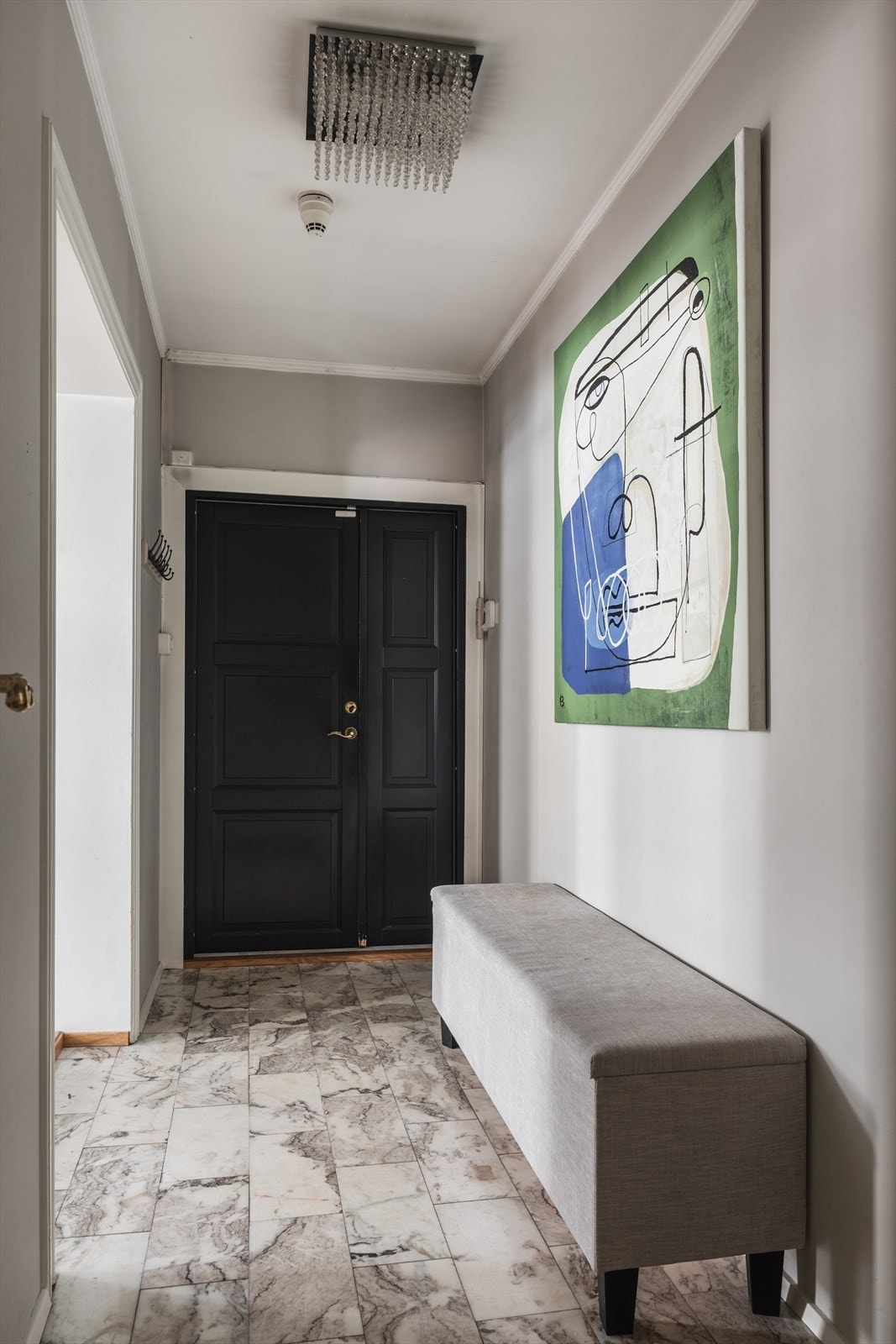 Innbydende entré med lekre fliser og behagelig gulvvarme. Praktisk garderobeskap i mellomgang. Galleribilde