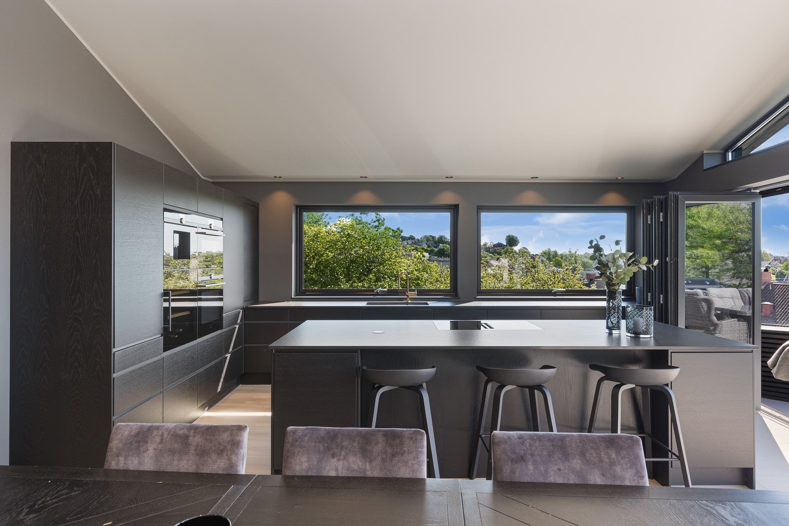 En kan ha barstoler rundt kjøkkenøy som skaper en sosial atmosfære på kjøkkenet Galleribilde