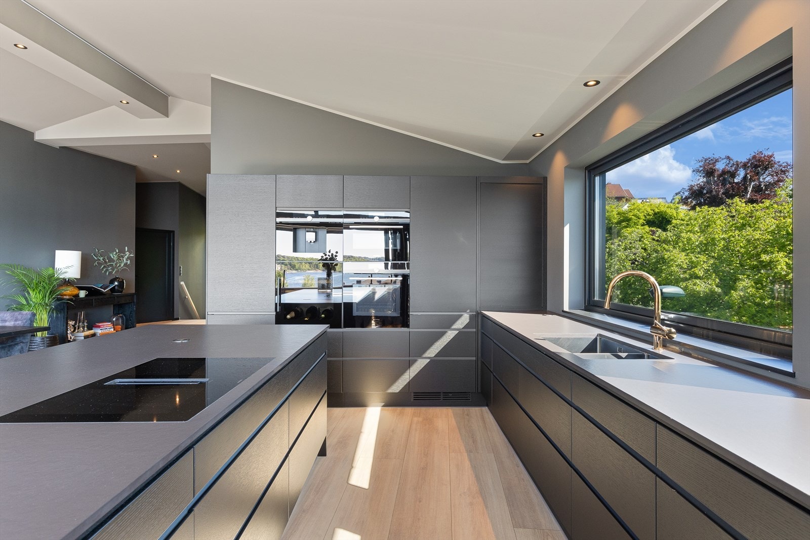 Kjøkkeninnredning med slette fronter, komposit oppvaskkum og integrerte hvitevarer Galleribilde