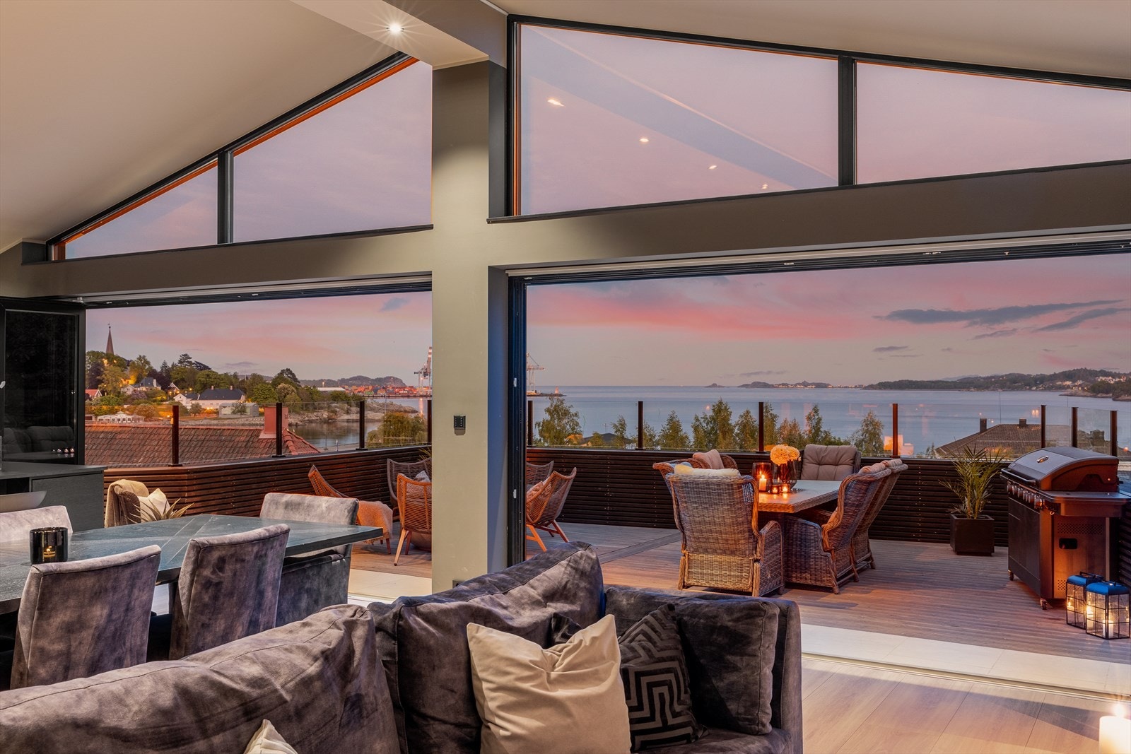 Fra stuen er det store foldedører i glass ut til den store terrassen Galleribilde