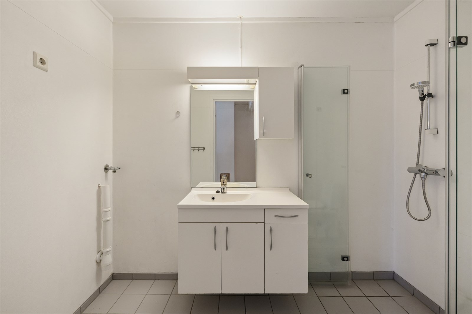 Badet er innredet med en hvit baderomsinnredning med underskap og heldekkende servant, speil og overskap. Galleribilde