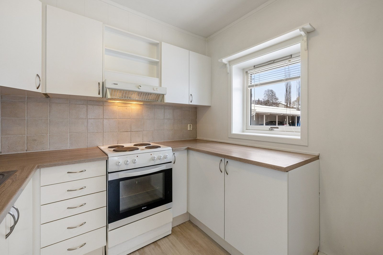 Kjøkkenet er fra 2003 og har en pen innredning med hvite, glatte fronter og laminert benkeplate med nedfelt oppvaskkum. Galleribilde