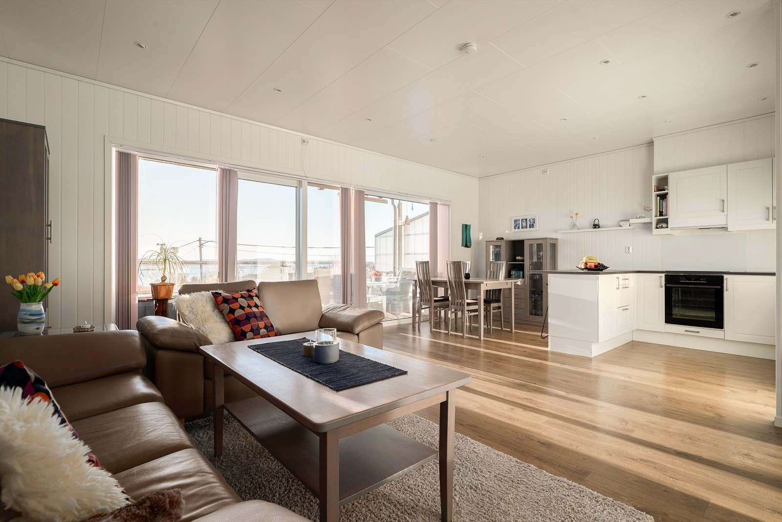 Store vindusflater i stuen slipper inn rikelig med dagslys. Galleribilde