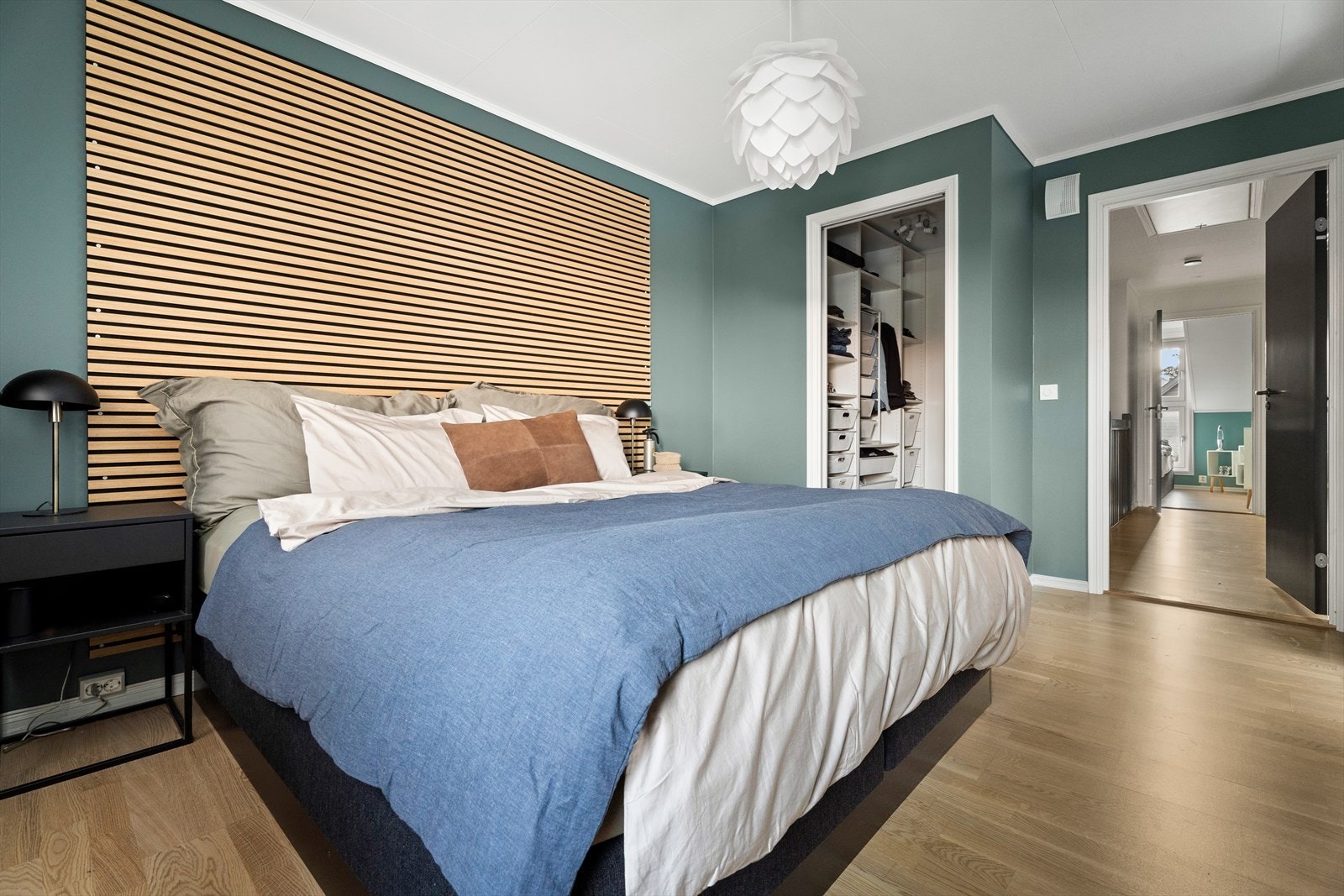 Direkte tilgang til garderobe gir effektiv oppbevaring, og rommet har malte vegger med spiledekor. Galleribilde