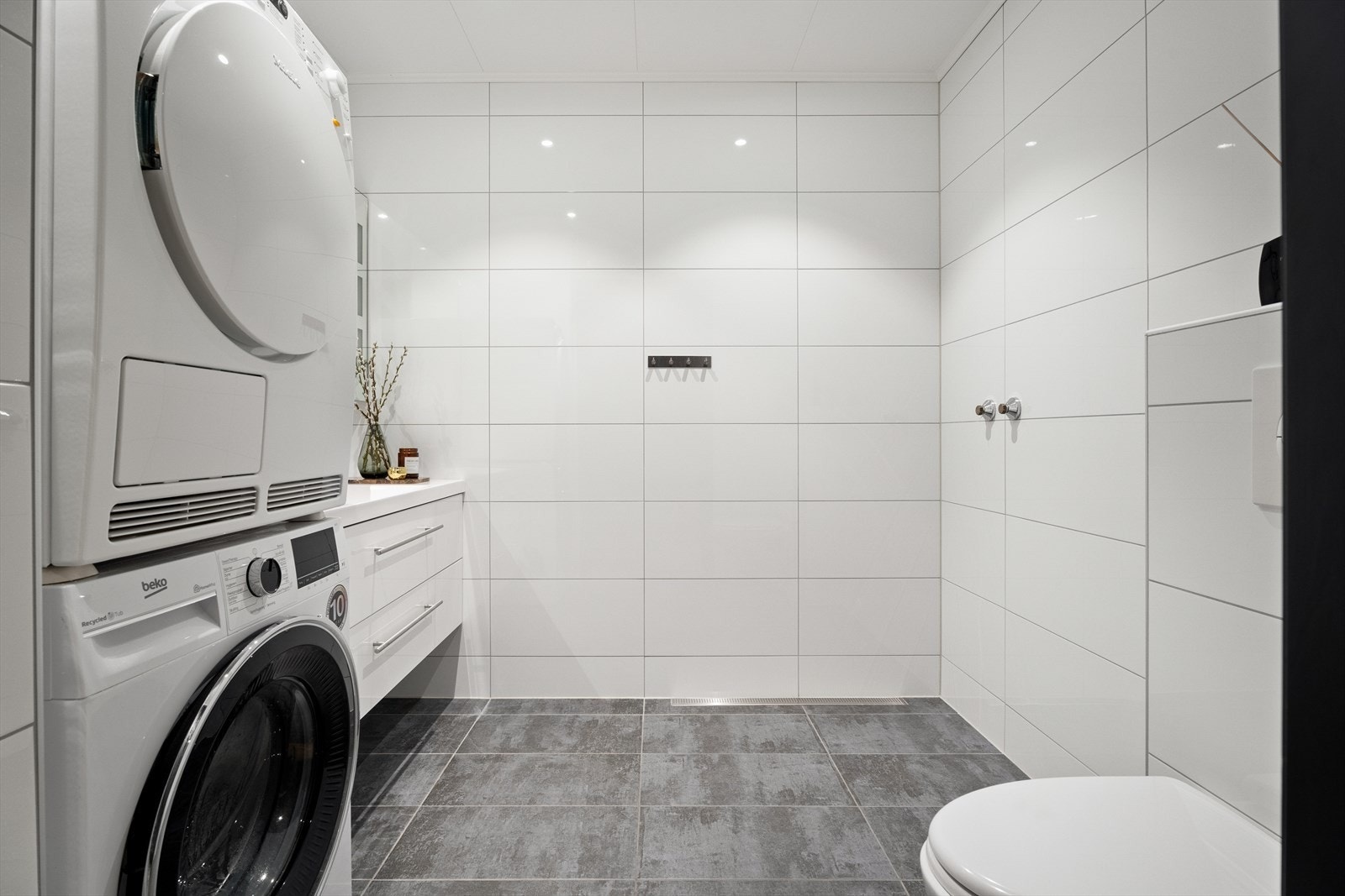 Bad/vaskerom i første etasje. Fliser på vegg og gulv gir et robust våtrom med elektriske varmekabler. Galleribilde