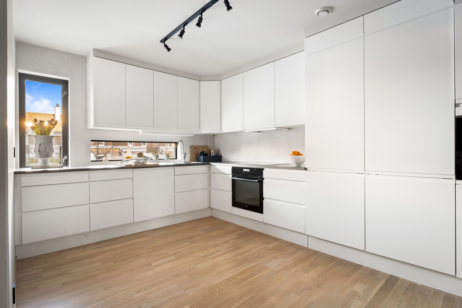 Aubo kjøkken med hvite slette fronter og laminert benkeplate gir et ryddig arbeidsområde. Galleribilde