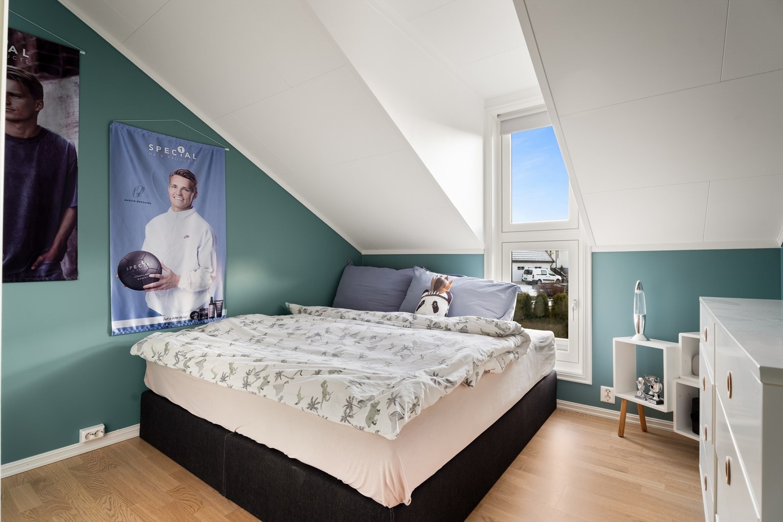 Skråtak og parkettgulv gir rommet karakter, mens vinduet slipper inn naturlig lys. Galleribilde