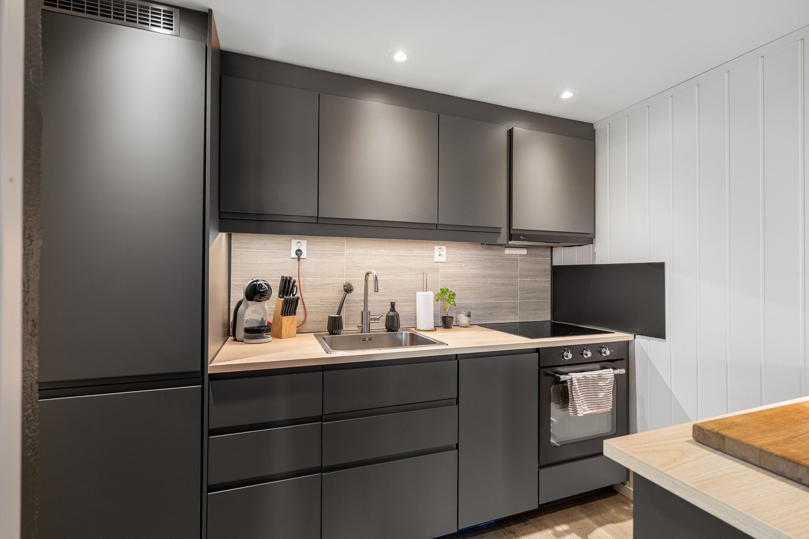 Kjøkken med integrert platetopp, stekeovn, kjøle/fryseskap og oppvaskmaskin. Galleribilde