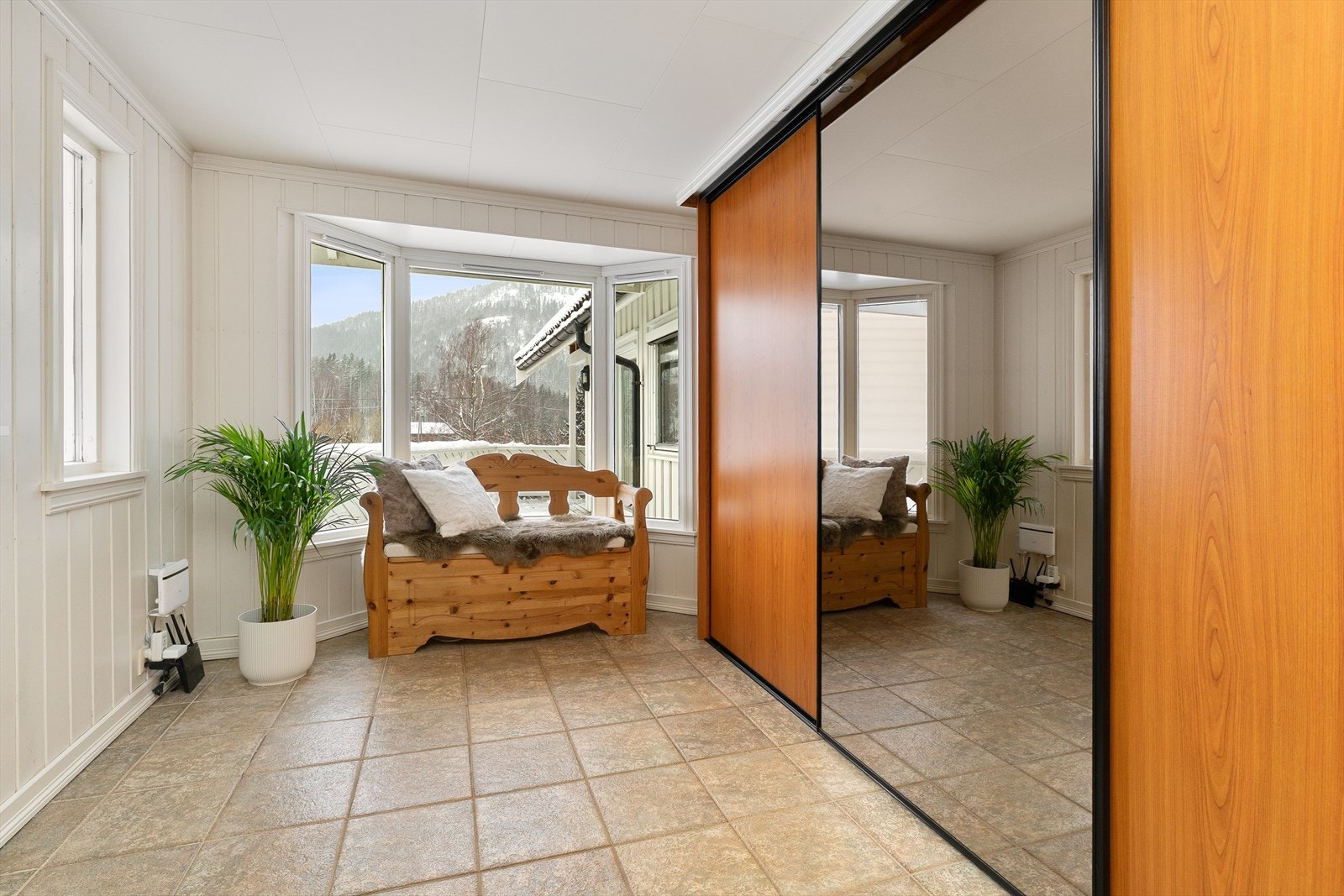 Boligen har en romslig entré med to skyvedørsgardrober. Gulvet har fliser og elektriske varmekabler, veggene er dekt med panel og taket har himlingsplater. Galleribilde