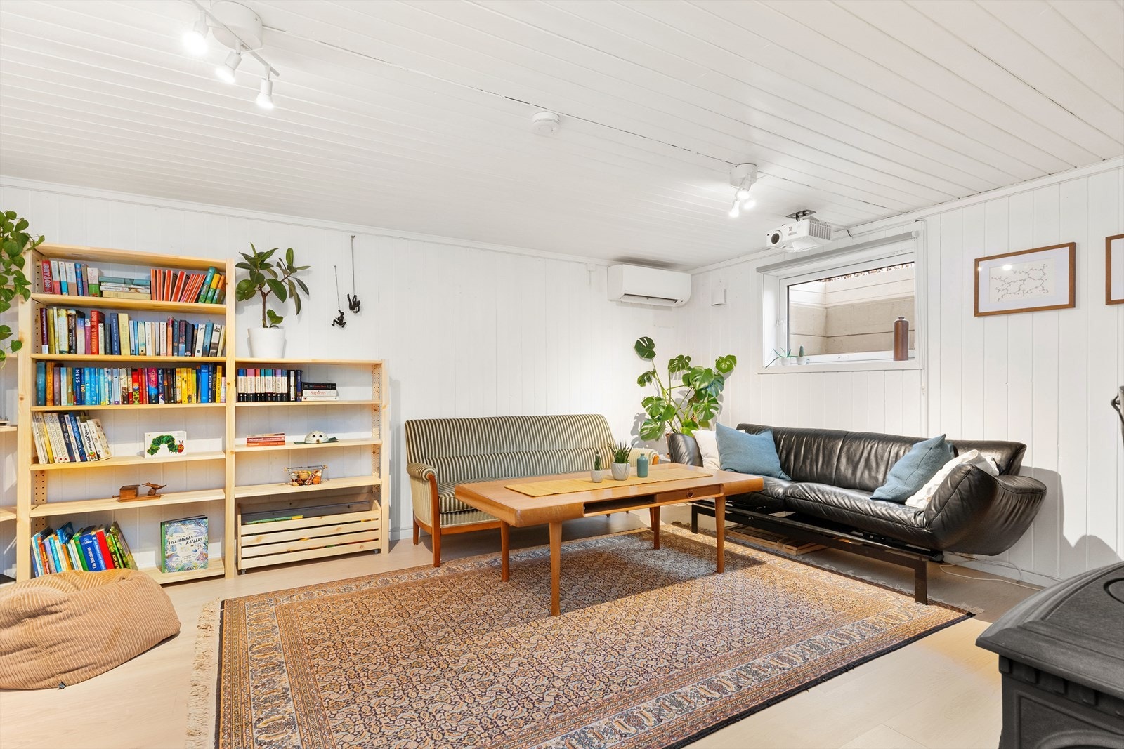 I kjellerstuen er det både varmepumpe og vedovn. Prosjektor medfølger i salget. Galleribilde