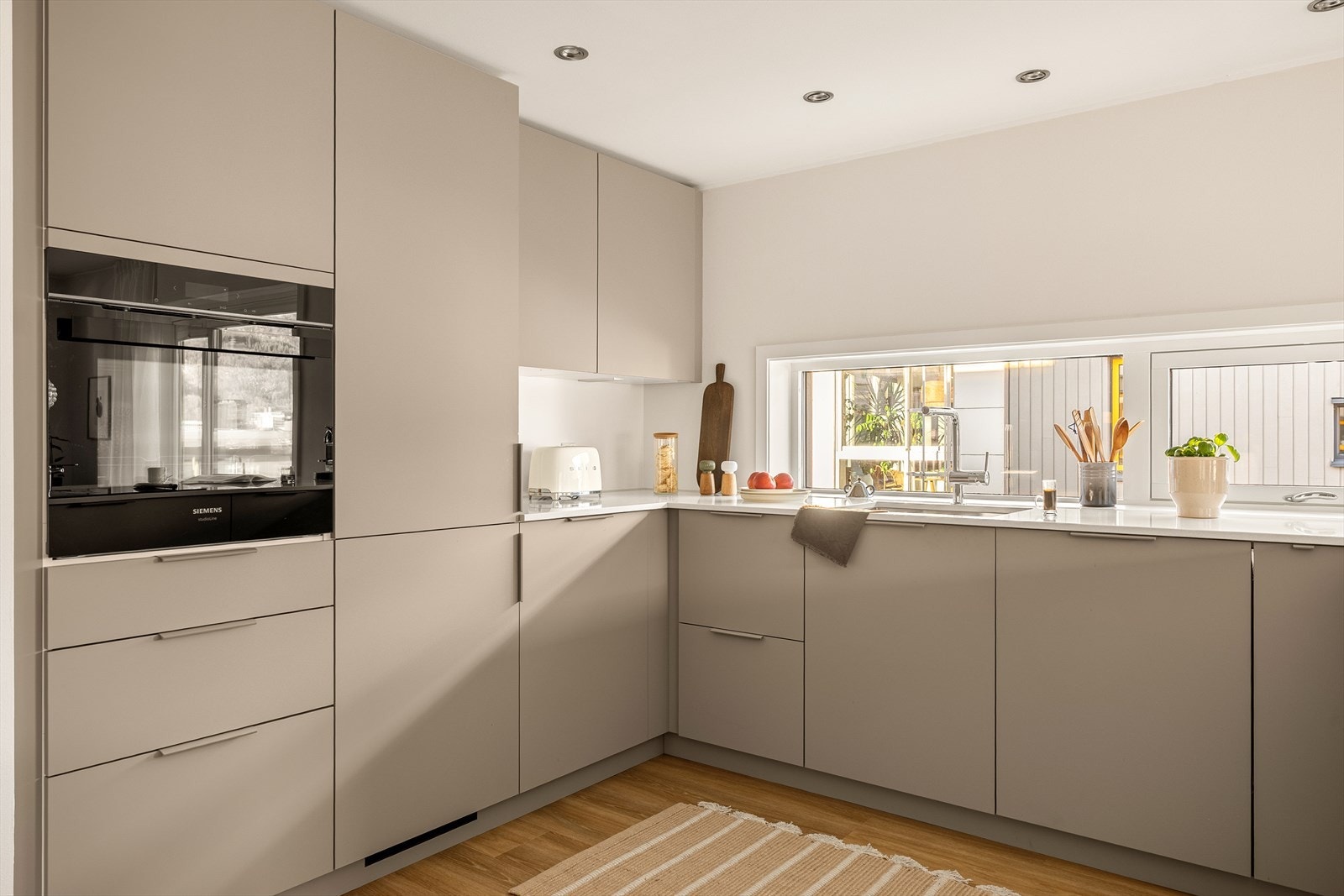 Integrerte hvitevarer fra Siemens gir et helhetlig og ryddig preg, samtidig som de bidrar til høy brukskomfort. Kjøkkenet har naturlig tilknytning til spiseplass og stue, noe som gjør det enkelt å være sosial også når man lager mat. Galleribilde