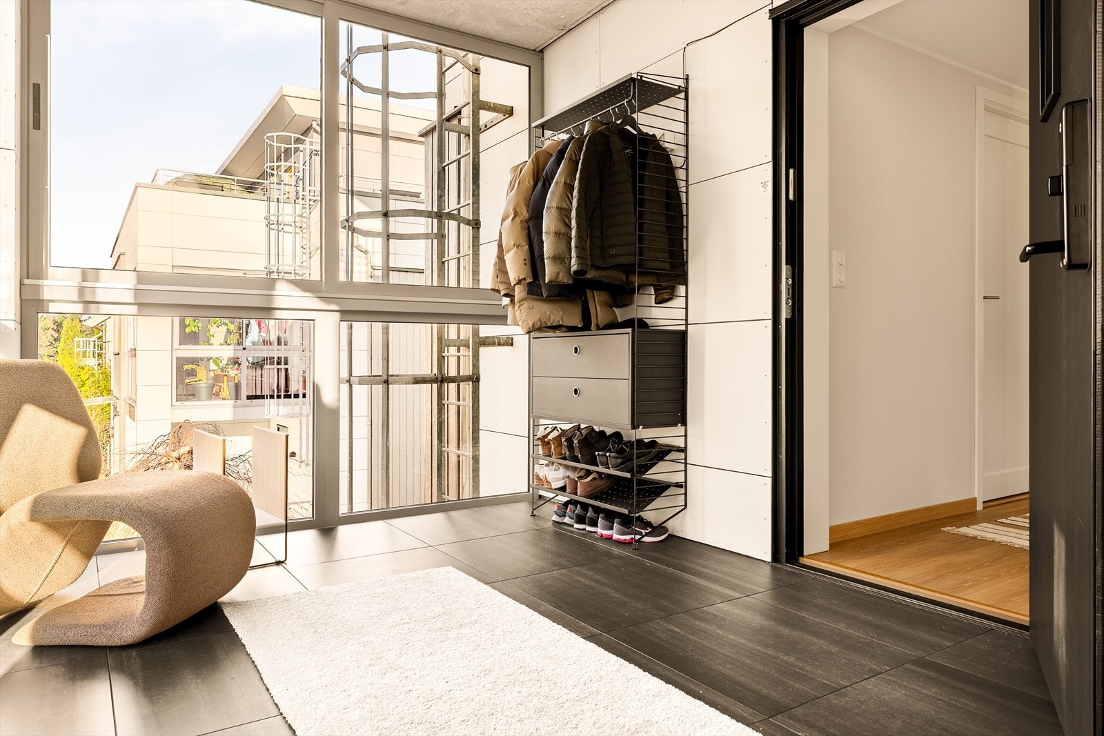 Den innglassede entréen gir et lyst og luftig førsteinntrykk, med rikelig dagslys som slipper inn allerede ved ankomst. Glassflatene skaper en åpen følelse og gir en fin overgang mellom ute og inne, samtidig som entréen er skjermet og praktisk i bruk. Galleribilde