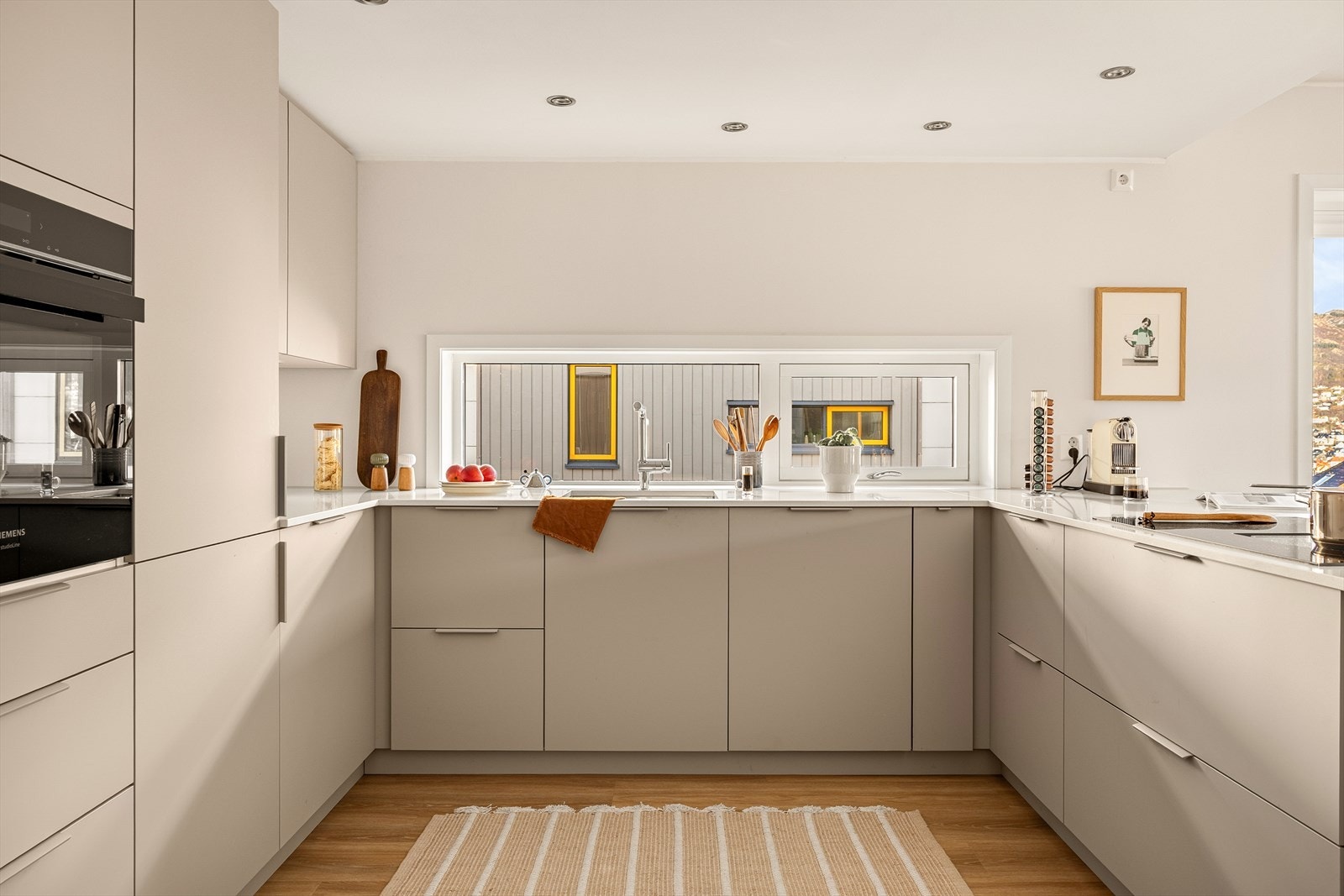 Innredningen er levert av Kvik og har et tidløst uttrykk med rene linjer og gjennomtenkte løsninger. De gode arbeidsflatene og den praktiske utformingen gjør kjøkkenet velegnet både til daglig bruk og til mer sosiale anledninger. Galleribilde