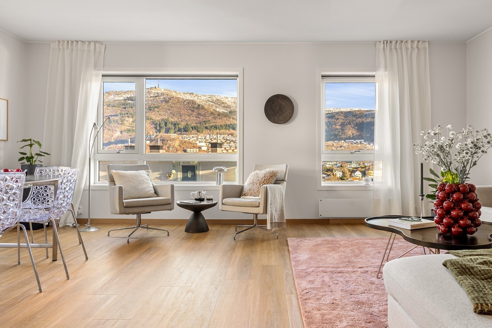 Vindusflatene skaper en åpen og luftig atmosfære, og gir samtidig flott utsyn mot omgivelsene og byfjellene. Lysinnslippet bidrar til en behagelig romfølelse og gjør oppholdsrommet innbydende både på lyse sommerdager og i mørkere årstider. Galleribilde