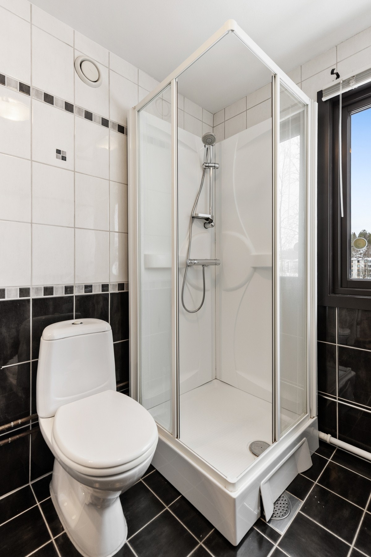 Rommet er innredet med gulvmontert toalett, nedfelt servant med tilhørende innredning og speil, dusjkabinett og opplegg for vaskemaskin. Galleribilde