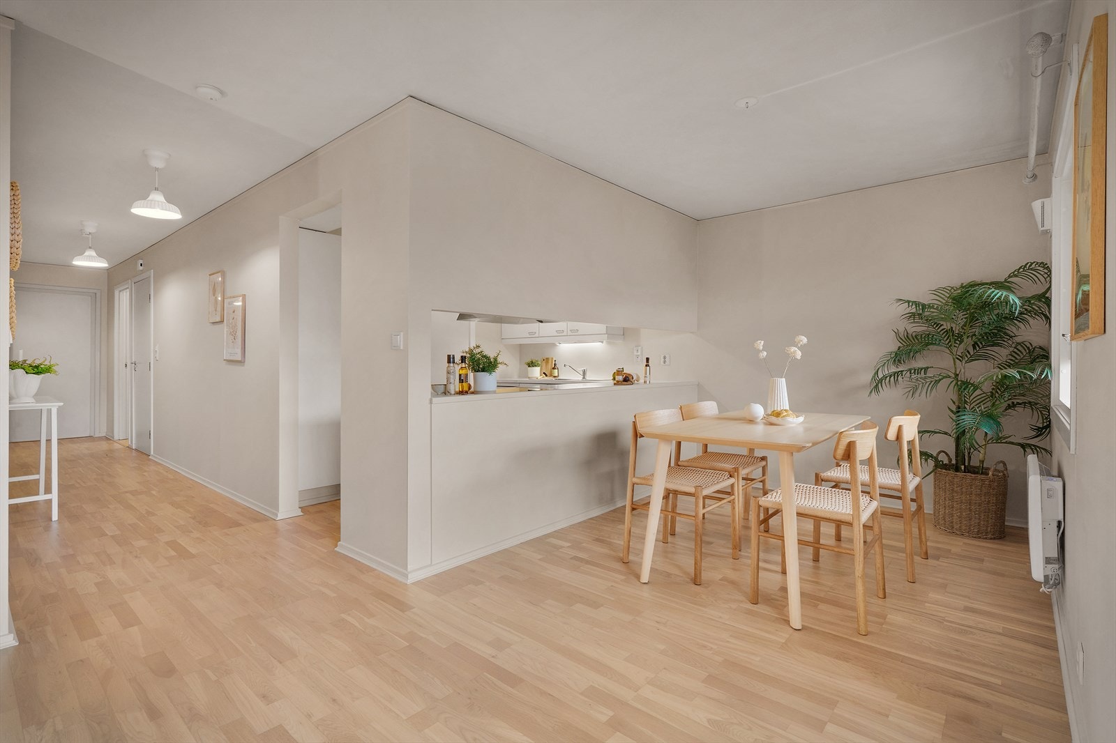 Åpning i veggen mellom kjøkken og spiseplass gir en naturlig forbindelse og enkel servering. Galleribilde